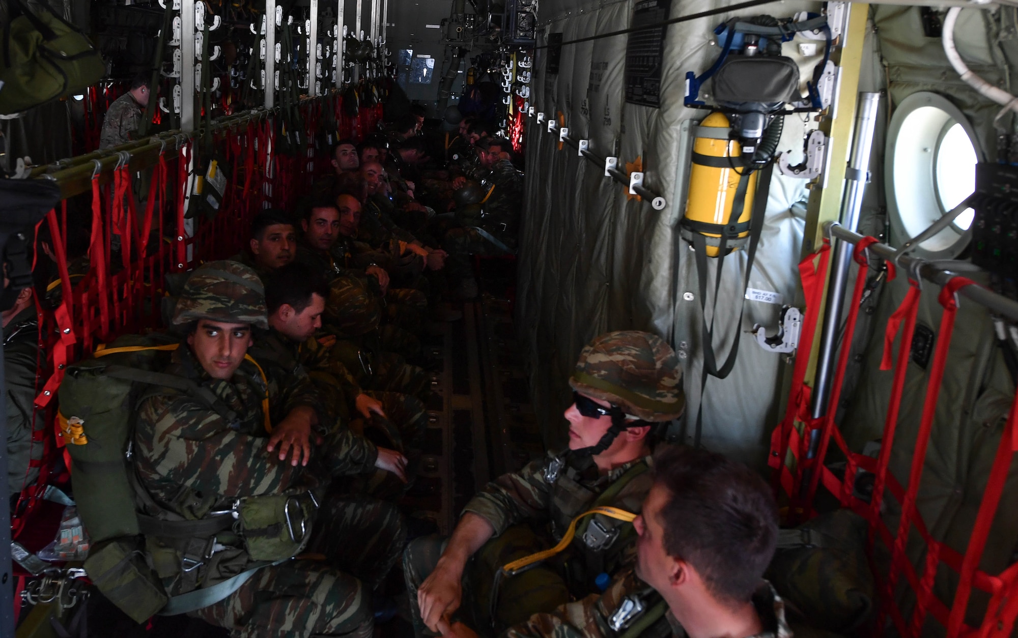 Greek paratroopers sit inside a U.S. Air Force C-130J Super Hercules during Exercise Stolen Cerberus IV at Elefsis Air Base, Greece, April 26, 2017. Approximately 40 paratroopers performed static-line and military free-fall jumps from the C-130. Combined exercises such as these enhance the interoperability capabilities and skills among allied and partner armed forces. (U.S Air Force photo by Senior Airman Tryphena Mayhugh)