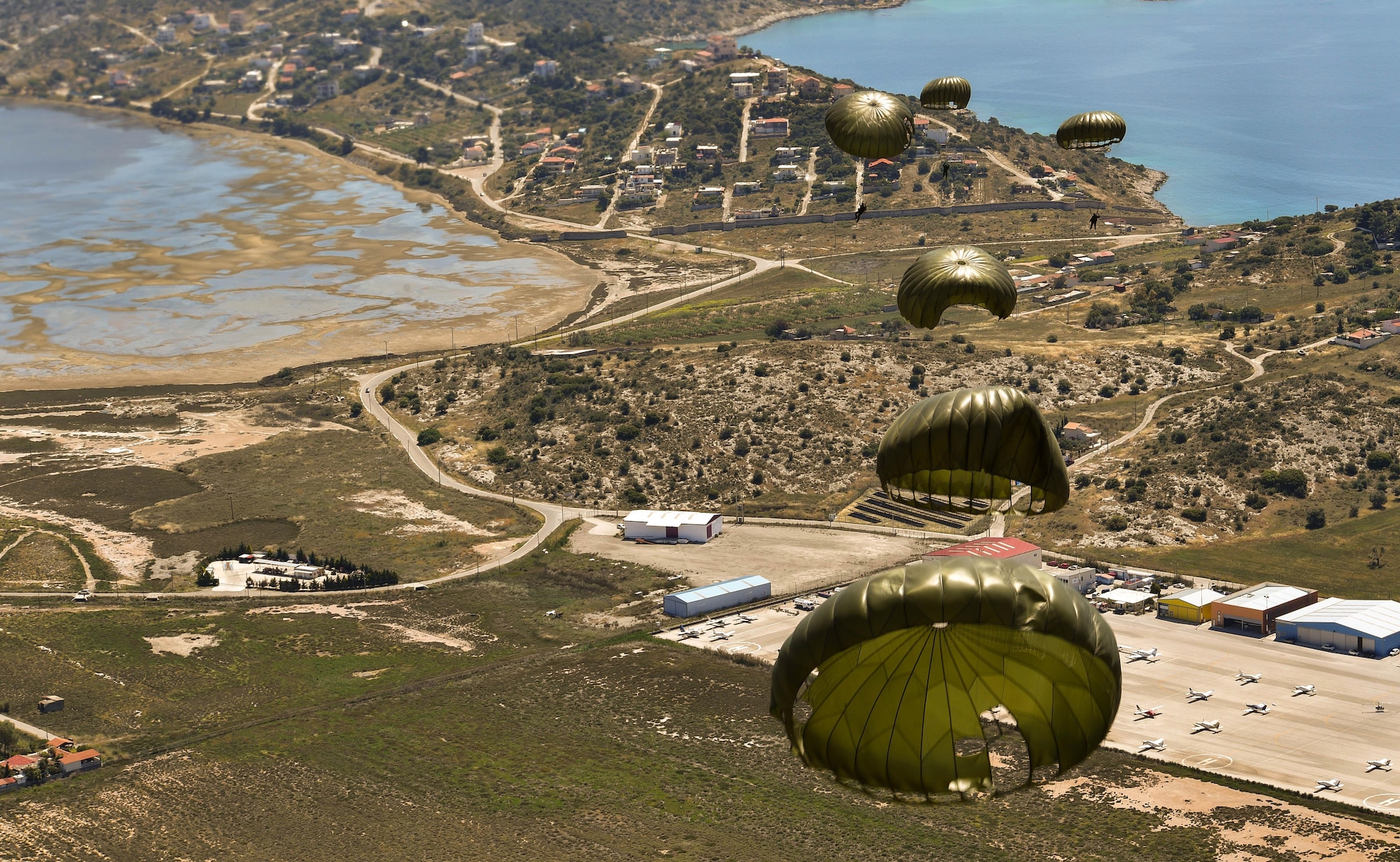 Greek paratroopers conduct a static-line jump from a U.S. Air Force C-130J Super Hercules during Exercise Stolen Cerberus IV above Megara, Greece, April 26, 2017. Throughout the exercise, U.S. Air Force and Army servicemembers worked alongside the Hellenic air force to achieve personnel and cargo drops. The purpose of the exercise was to train U.S. and Greek forces while strengthening the partnership between two NATO allies. (U.S Air Force photo by Senior Airman Tryphena Mayhugh)