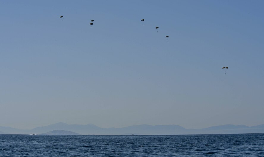 Six Greek paratroopers and a rigging alternate method zodiac kit descend to the Mediterranean Sea after jumping from a U.S. Air Force C-130J Super Hercules during Exercise Stolen Cerberus IV near Elefsis Air Base, Greece, April 27, 2017. During this fourth iteration of the exercise, it was the first time U.S. and Greek servicemembers trained for this type of drop. Through exercises such as this the U.S. strengthens its partnership with its NATO allies. (U.S Air Force photo by Senior Airman Tryphena Mayhugh)