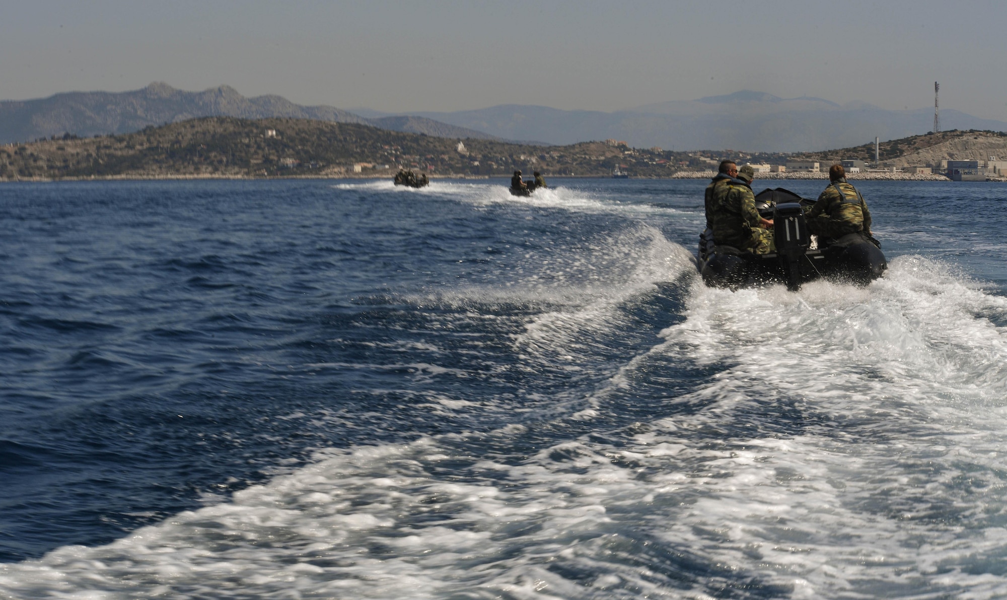 U.S. and Greek servicemembers return to shore after participating in a sea-rescue and rigging alternate method zodiac kit air drop during Exercise Stolen Cerberus IV near Elefsis Air Base, Greece, April 27, 2017. The sea-rescue and RAMZ kit, along with six Greek paratroopers, were dropped from a U.S. Air Force C-130J Super Hercules. U.S. Air Force and Army service members trained alongside the Hellenic air force in personnel and cargo drops during the fourth iteration of the exercise in Greece. (U.S Air Force photo by Senior Airman Tryphena Mayhugh)