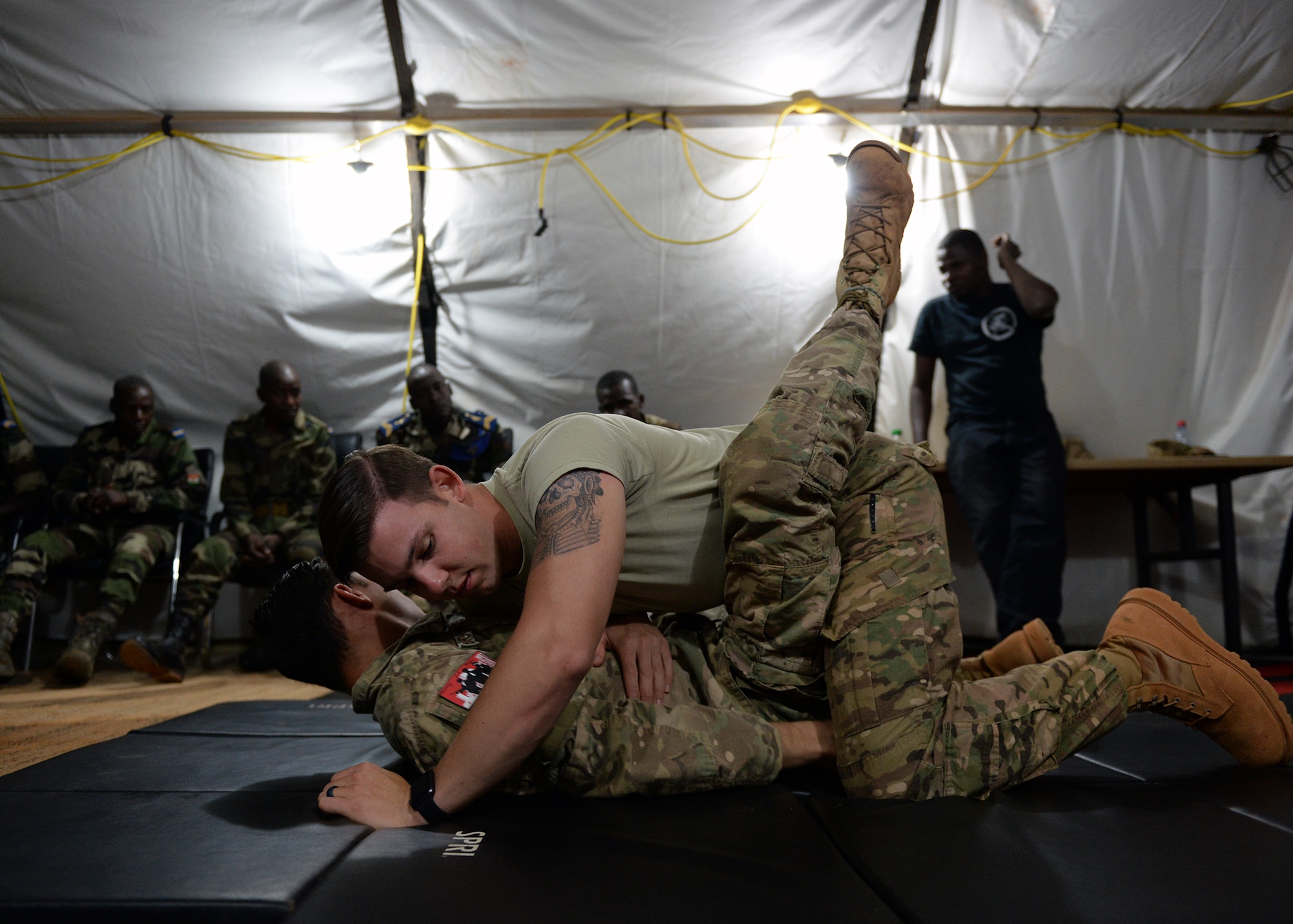 Senior Airmen Joshua Brooks and Jacob Myers, 768th Expeditionary Air Base Squadron air advisors, demonstrate a jiu jitsu maneuver to members of the Forces Armées Nigeriennes at Nigerien Air Base 101, Niger, April 4, 2017. The training was part of a larger joint knowledge exchange to help train and build relations with the FAN. (U.S. Air Force photo by Senior Airman Jimmie D. Pike)