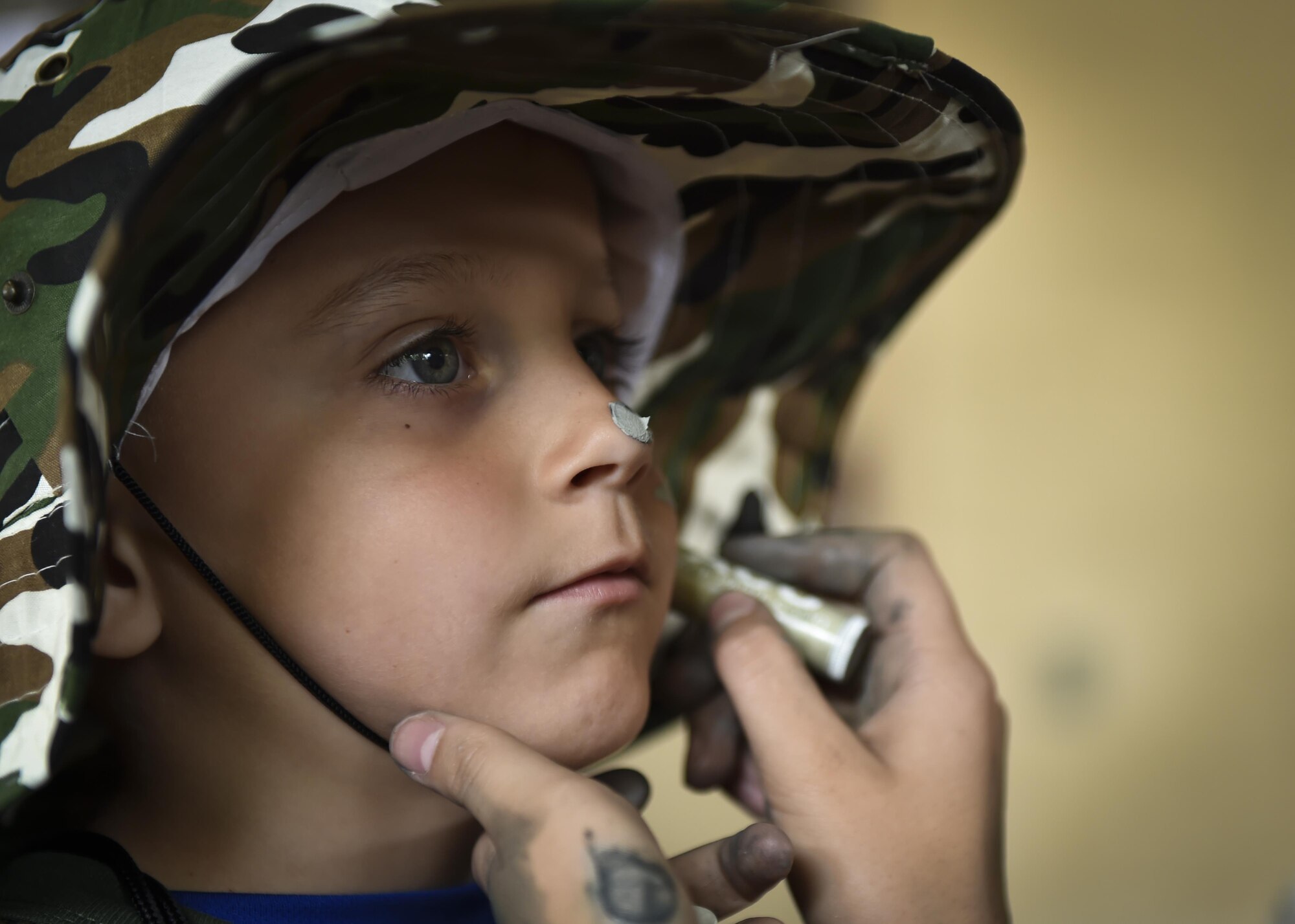 A military child gets his face painted prior to deploying during Operation Kids Understanding Deployment Operations at Hurlburt Field, Fla., April 22, 2017. Operation KUDOS is an educational event aimed to help build resilience in military youth by engaging them in activities that simulate the pre-deployment experience, such as pre-deployment lines and demonstrations. (U.S. Air Force photo by Airman 1st Class Joseph Pick)