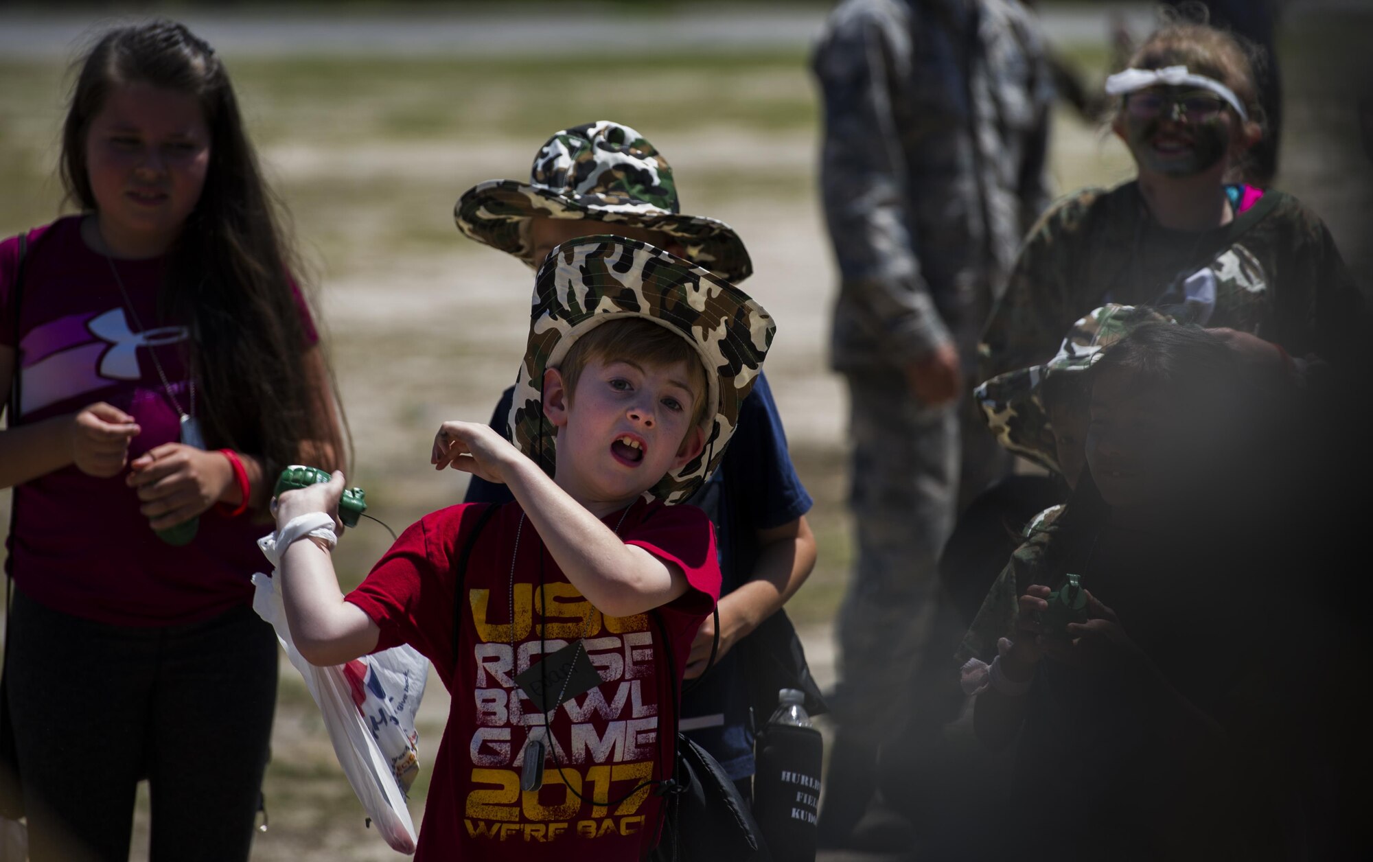 A military child throws a simulated grenade during Operation Kids Understanding Deployment Operations at Hurlburt Field, Fla., April 22, 2017. Operation KUDOS is an educational event aimed to help build resilience in military youth by engaging them in activities that simulate the pre-deployment experience, such as pre-deployment lines and demonstrations. (U.S. Air Force photo by Airman 1st Class Joseph Pick)