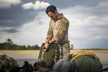 Senior Airman Matt, 38th Rescue Squadron pararescueman, readies a static-line parachute prior to a jump, April 24, 2017, at Moody Air Force Base, Ga. All PJs are qualified to conduct both static-line and High altitude, low opening jumps. During a static-line jump, the jumper is attached to the aircraft via the ‘static-line’, which automatically deploys the jumpers’ parachute after they’ve exited the aircraft. (U.S. Air Force photo by Staff Sgt. Ryan Callaghan)