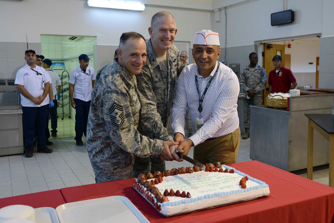 U.S. Air Force Command Chief Master Sgt. Thomas Cooper (left), Col. John Walker, 39th Air Base Wing commander (center), and Mehmet Kahvecioglu, senior Turkish manager for food services, cut a cake at the grand opening of the Larger Than Life Fitness Center and Titan Dining Facility May 1, 2017, at Incirlik Air Base, Turkey. Both facilities were opened in the former Department of Defense Dependents School on base. (U.S. Air Force photo by Airman 1st Class Devin M. Rumbaugh)