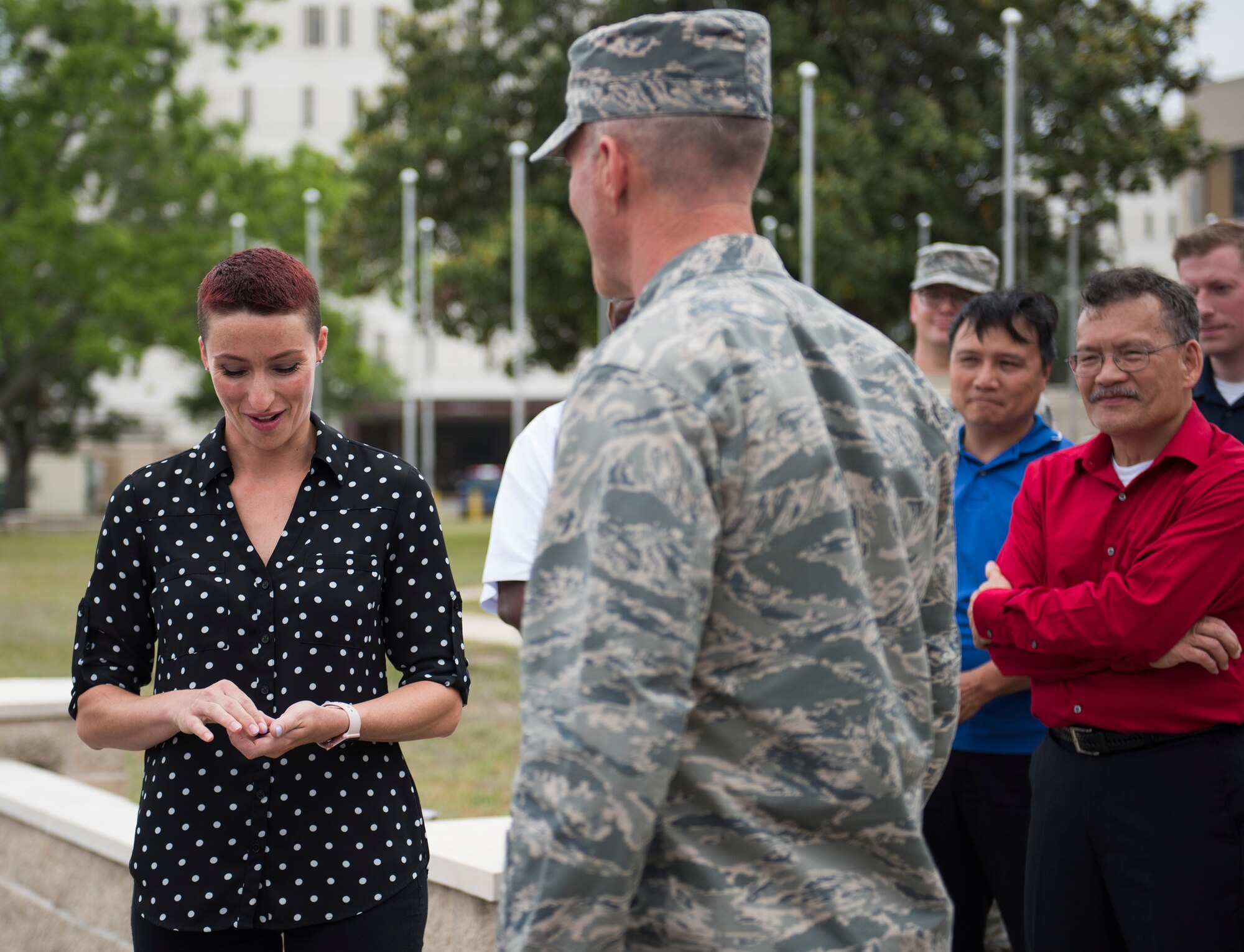 Esther Quast, 96th Logistics Readiness Squadron, smiles as she looks at the challenge coin presented to her by the 96th Test Wing Commander, Brig. Gen. Christopher Azzano, April 27 during the all-civilian retreat ceremony at Eglin Air Force Base, Fla. The all-civilian retreat is held to show support for our military members. (U.S. Air Force photo/Ilka Cole)
