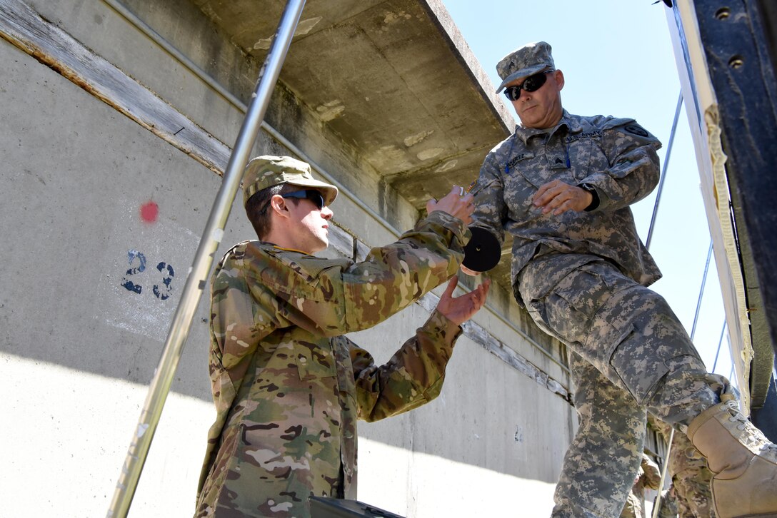 Sgt. Christopher Wuertz and Sgt. Kenneth Hill, both military police with the 354th MP Company, prepare targets for their teammate who is preparing to fire their M-16.  Wuertz and Hill were competitors in the 2017 U.S. Army Reserve Midwestern Small Arms Championship at Camp Atterbury, Indiana April 21-25.