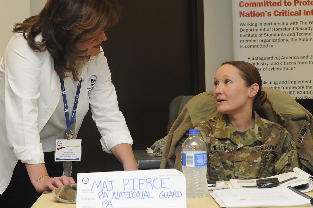 Heidi Cooke, senior learning consultant with the International Society of Automation, speaks with Maj. Christine Pierce, Pennsylvania National Guard Defensive Cyber Operations Elements team chief and participant of the ISA CS34/CS37 62443 Cybersecurity Design Specialist/Maintenance Specialist course as part of Cyber Shield 17 at Camp Williams, Utah, April 26, 2017. Cyber Shield 17 is the sixth iteration of this training exercise and this year unites the Army National Guard with members of the Air National Guard, Army Reserve, and civilians from private companies, state government agencies, federal agencies, industry partners, and academia. (U.S. Army National Guard photo by Sgt. Michael Giles)