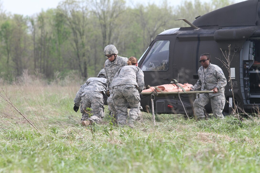 Army Reserve Spc. Ryan Flores and Spc. Bailey Jungmann of the 469th Medical Company, Wichita, Kansas team up with Air Force Staff Sgt. Cherrelle Warren and Airman 1st Class Echo Heldreth of the 779th Medical Group, Macdill Air Force Base, Tampa, Florida rush to transport a mannequin patient from a UH-60 Black Hawk helicopter at Responders Support Camp (RSC) Nighthawk, Indiana during Guardian Response 17 on April 29, 2017. 

Nearly 5,000 Soldiers and Airmen from across the country are participating in Guardian Response 17, a multi-component training exercise to validate the military's ability to support Civil Authorities in the event of a Chemical, Biological, Radiological, and Nuclear (CBRN) catastrophe. (U.S. Army Reserve photo by Staff Sgt. Christopher Sofia/Released)