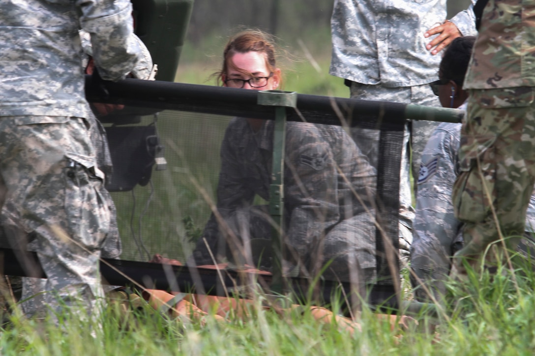 Airman 1st Class Echo Heldreth kneels as she prepares to lift a mannequin patient into a M997 4 litter HMMWV at Responders Support Camp (RSC) Night Hawk, Camp Atterbury, Indiana during Guardian Response 17 on April 29, 2017. 

Nearly 5,000 Soldiers and Airmen from across the country are participating in Guardian Response 17, a multi-component training exercise to validate the military's ability to support Civil Authorities in the event of a Chemical, Biological, Radiological, and Nuclear (CBRN) catastrophe. (U.S. Army Reserve photo by Staff Sgt. Christopher Sofia/Released)