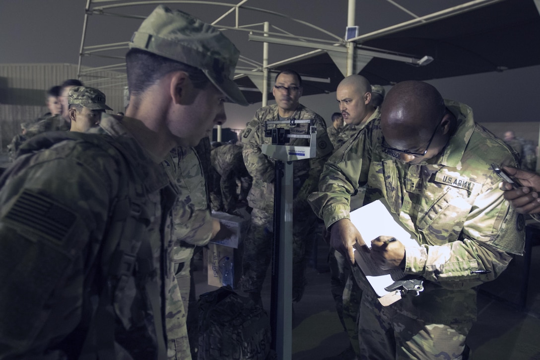 Chief Warrent Officer 2 Gary Johnson, an Information Officer, with the 316th Sustainment Command (Expeditionary), weighs the ruck-sack of 1st Lt. John Gaul, a mobility officer with the 316th ESC, in preparation for the ruck march portion of the German Armed Forces Badge qualification. The German Armed Forces Badge for Military Proficiency is one of the most sought after foreign awards in the United States Army. The 316th ESC and the 1st Sustainment Command (Theater) had the privilage of hosting the award qualifications at Camp Arifjan, Kuwait April 27, 2017.