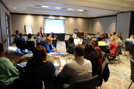 Chaplain (Col.) Erik Feig, standing right, command chaplain for 88th Regional Support Command, and his wife Stacey, standing right, welcome Soldiers and their spouses  to a Strong Bonds event in suburban Minneapolis, April 21. The goal of the Strong Bonds program is to increase individual Soldier and Family member readiness through relationship education and skills training.