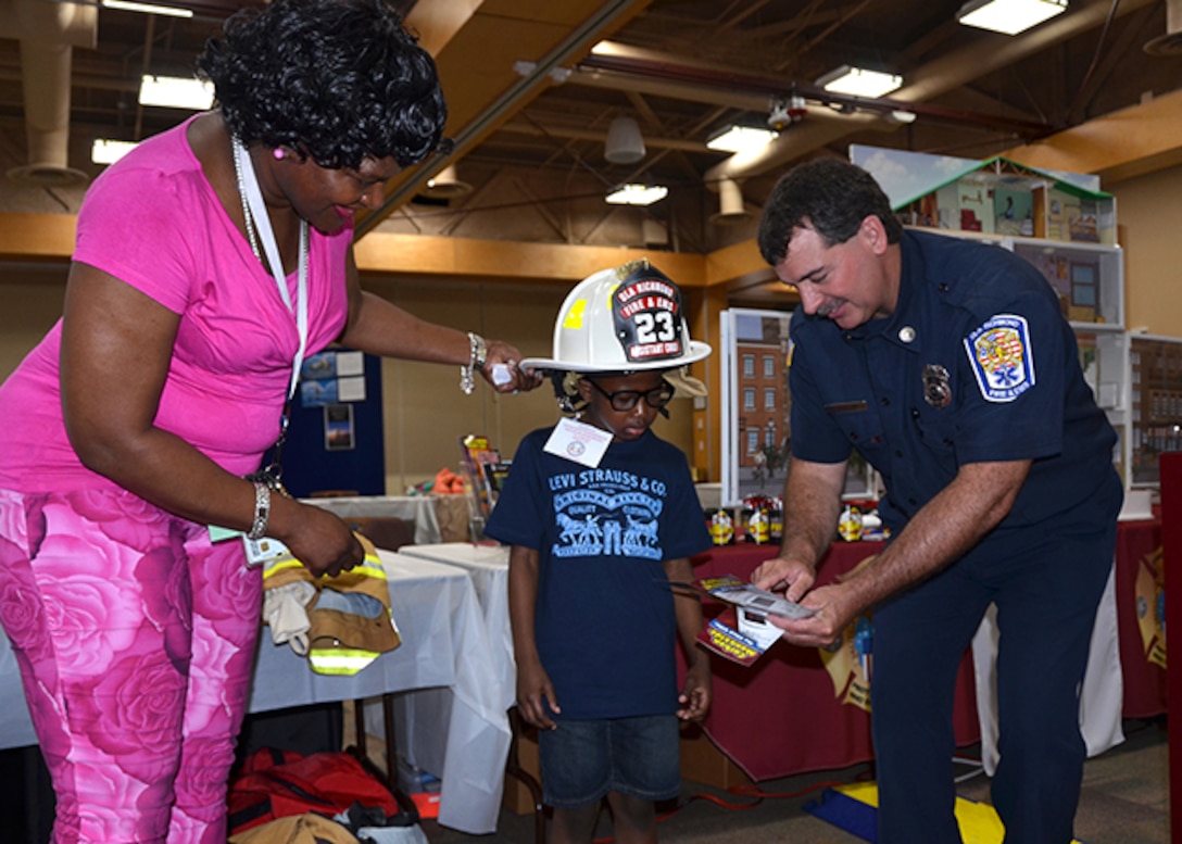 Michael Malone, a student from George Washington Carver Elementary School in Richmond, Virginia, wears a fire hat and visits with Fire Inspector Kevin Gordon, with DLA Installation Support at Richmond’s Fire Department, during Defense Supply Center Richmond’s Take Your Daughters and Sons to Work Day April 27, 2017. (Photo by Jackie Roberts)