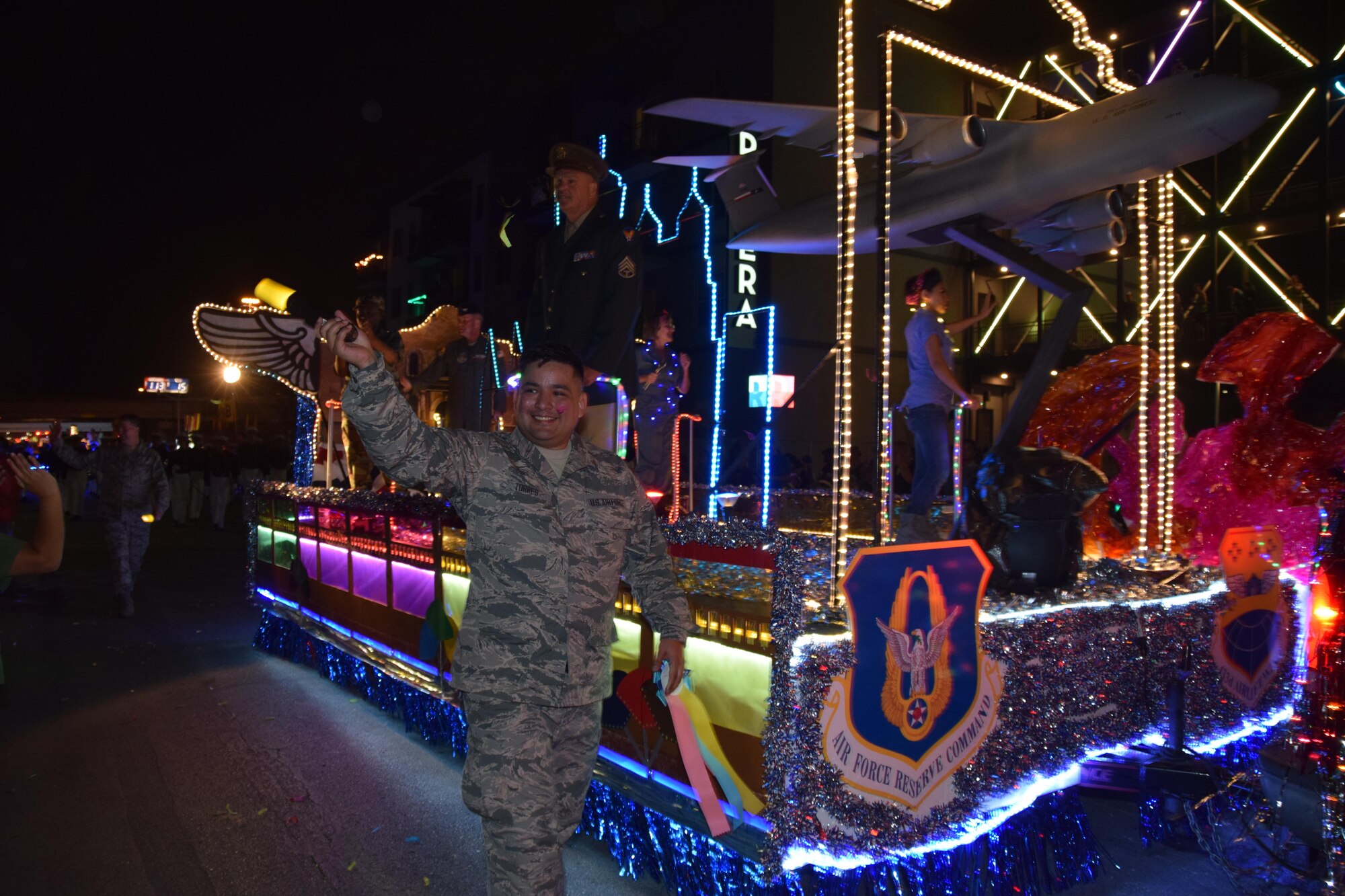 Senior Airman Joshua Torres, a 433rd Medical Squadron diagnostic imaging technician, waves to a portion of the 700,000 spectators during the 69th annual Fiesta Flambeau Parade, April 29, 2017 in San Antonio. The parade's theme was “City Lights and Celebrations.” and according to the Fiesta San Antonio website, is “The largest illuminated night parade in the world.” An estimated, 750,000 viewers (television and internet) watched the 2017 parade. (U.S. Air Force Photo/ Tech. Sgt. Carlos J. Trevino)