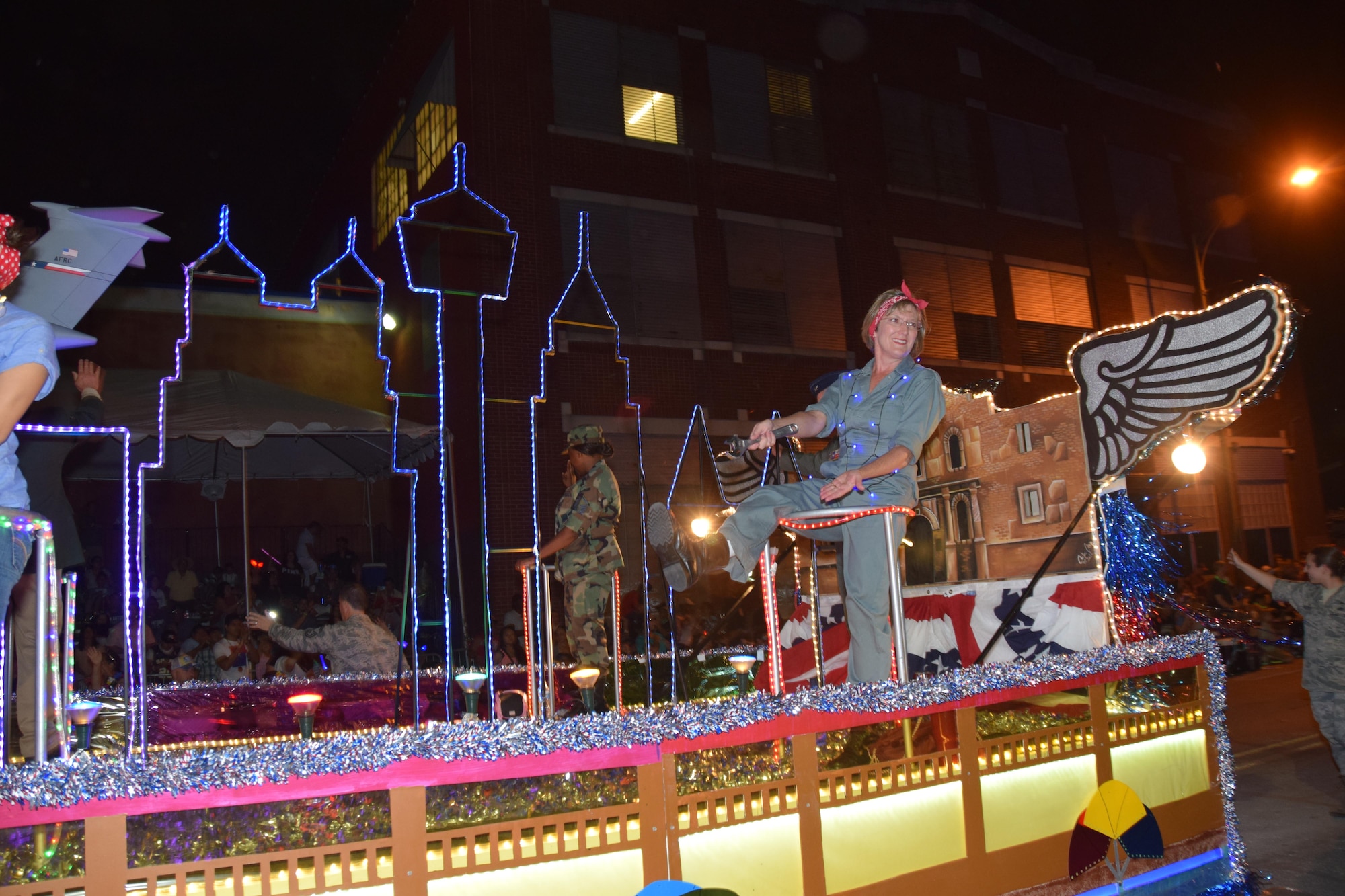 Mandy Scott, wife of Col. David A. Scott, 433rd Airlift Wing vice commander, responds to the crowds request to show her shoes at the 69th annual Fiesta Flambeau Parade, April 29, 2017. It is a tradition for spectators to request to see the shoes of ladies riding on the floats. The 433rd AW's “City Lights and Celebrations” themed float was seen by over 700,000 spectators lining the 2.6 mile long route on the downtown streets of San Antonio.  (U.S. Air Force Photo/ Tech. Sgt. Carlos J. Trevino)