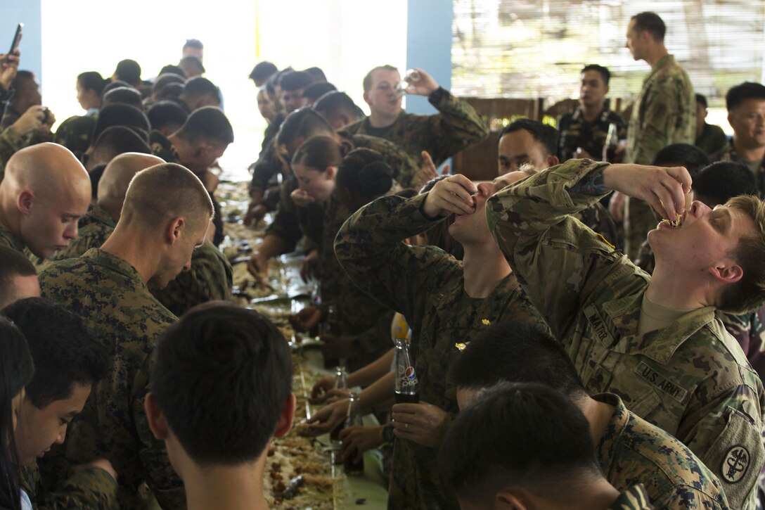 Philippine and U.S. troops participate in a Boodle Fight at Camp General Ceferino S. Carreon in Calinog, Iloilo, the Philippines, April 27, 2017. A Boodle Fight is a Filipino military tradition that symbolizes brotherhood and camaraderie. Balikatan is an annual U.S.-Philippine military bilateral exercise focused on humanitarian assistance, disaster relief, counter-terrorism and other military operations. Marine Corps photo by Lance Cpl. Nelson Duenas