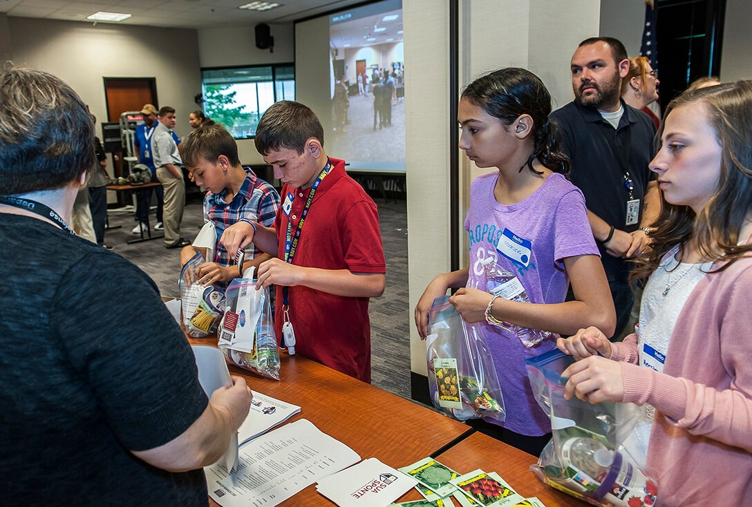 Children line up to create USO care packages for disabled and homeless veterans during DSCC's 'Take our daughters and sons to work day’. More than 100 children of DLA Land and Maritime and DFAS Columbus associates attended the annual event. This year's them was "Count on Me."