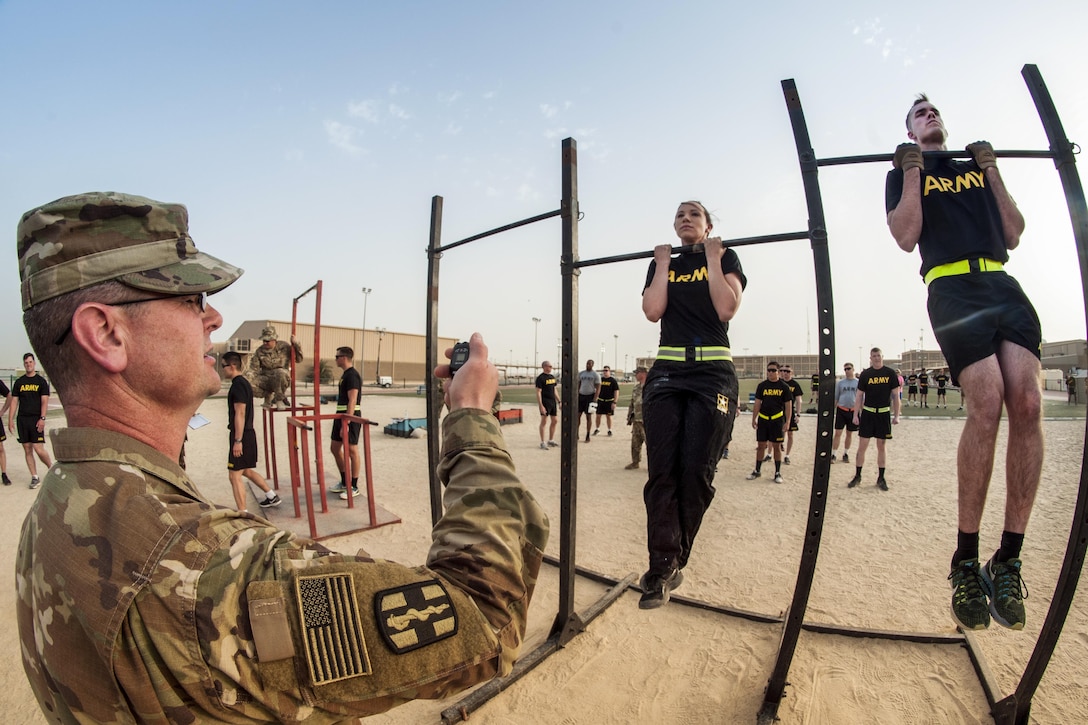 Soldiers participate in the flexed arm-hang during qualifications for the German Armed Forces Badge for Military Proficiency at Camp Arifjan, Kuwait, April 28, 2017. The soldiers are assigned to commands throughout U.S. Central Command. Army photo by Sgt. Christopher Bigelow