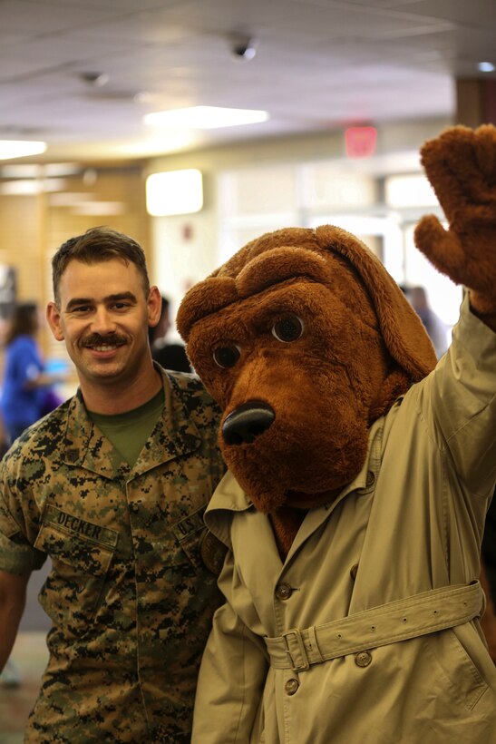 Sgt. James Decker, a military policeman, and “McGruff the Crime Dog” pose for a picture during the annual “Strike Out Child Abuse” event at K-Bay Lanes aboard Marine Corps Base Hawaii, April 26, 2017. The purpose of this event was to raise awareness and reach out to the community about ways to protect children from abuse. (U.S. Marine Corps Photo by Lance Cpl. Matthew Kirk)
