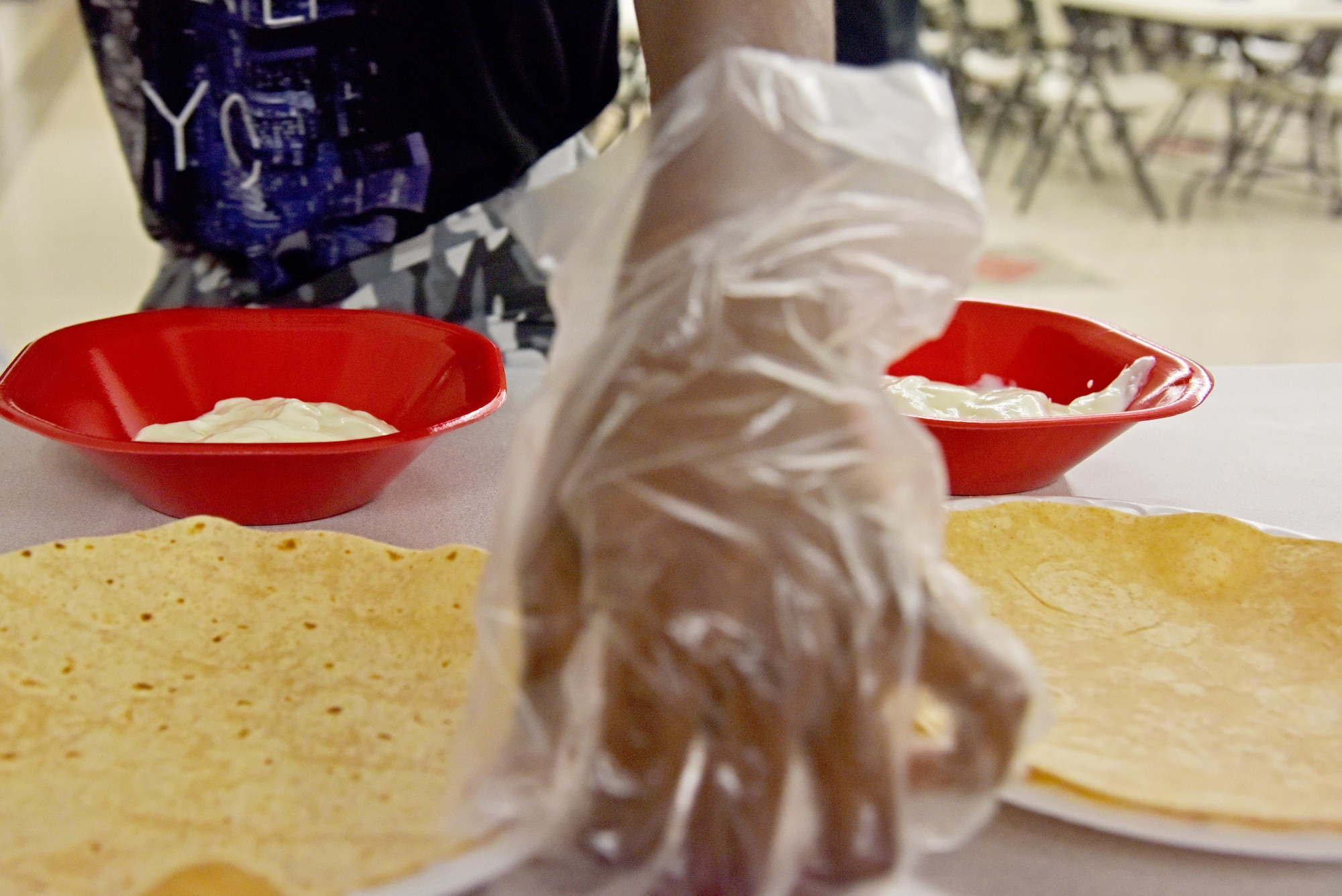 A teen prepares a quesadilla during Teen Chef Challenge at the Taylor Chapel on Goodfellow Air Force Base, Texas, April 28, 2017. The challenge pitted four teams of teens against each other to have their meals evaluated by a panel of judges. (U.S. Air Force photo by Staff Sgt. Joshua Edwards/Released)