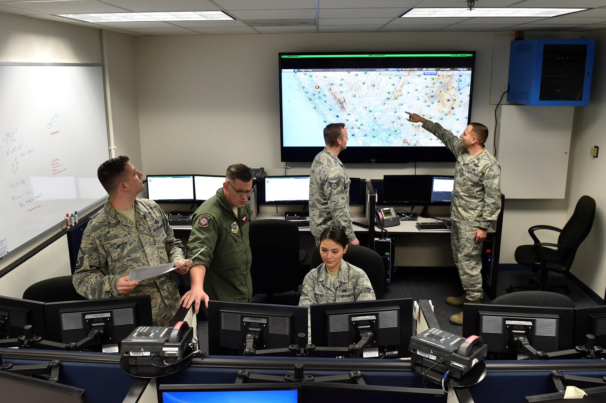 Airmen assigned to the 321st Air Mobility Operations Squadron, gather in their command and control center at Travis Air Force Base, Calif., during Exercise Cerberus Strike April 27, 2107. Throughout the exercise the AMOS showcased its ability to turn its command and control center to a fully functioning Air Mobility Division capable of supporting any aircrew anywhere in the world. (U.S. Air Force Photo by Tech. Sgt. Liliana Moreno)