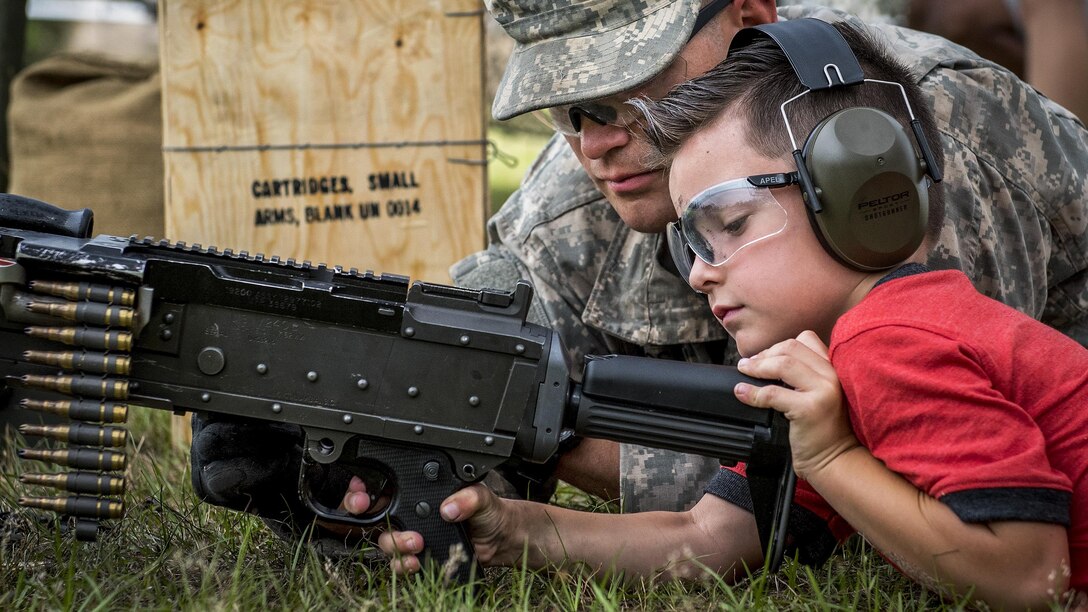 A soldier talks with a child about a machine gun during the 6th Ranger Training Battalion’s open house event at Eglin Air Force Base, Fla., April 29, 2017. The event provided an opportunity for the public to learn how Rangers train and operate. Air Force photo by Samuel King Jr.