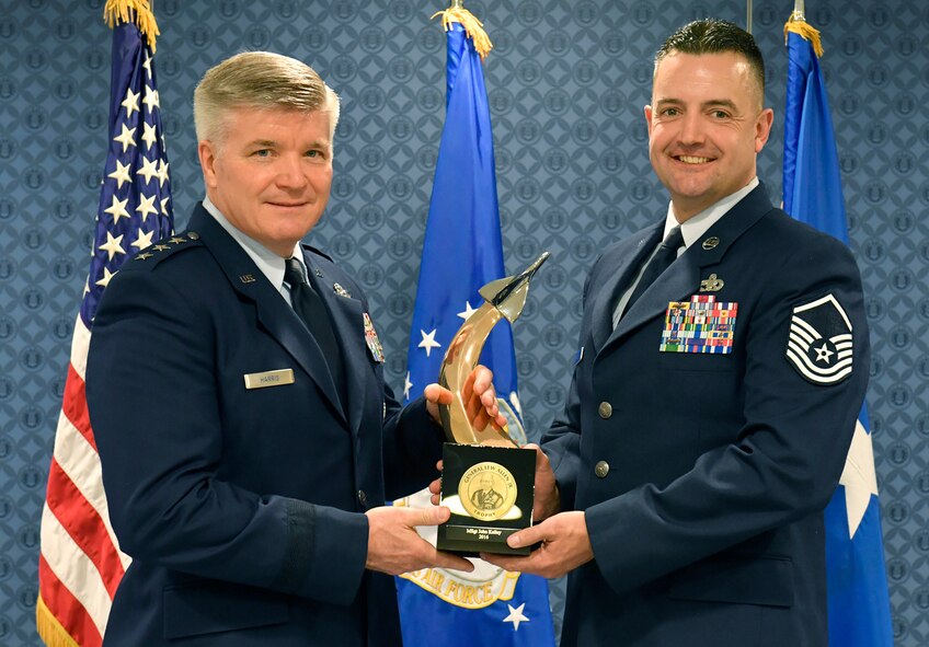 Lt. Gen. Jerry Harris, Deputy Chief of Staff for Strategic Plans, Programs and Requirements, presents Master Sgt. John Kelly the General Lew Allen Jr. Trophy for 2016, during a ceremony at the Pentagon, April 21, 2017.  (U.S. Air Force photo/Wayne A. Clark)