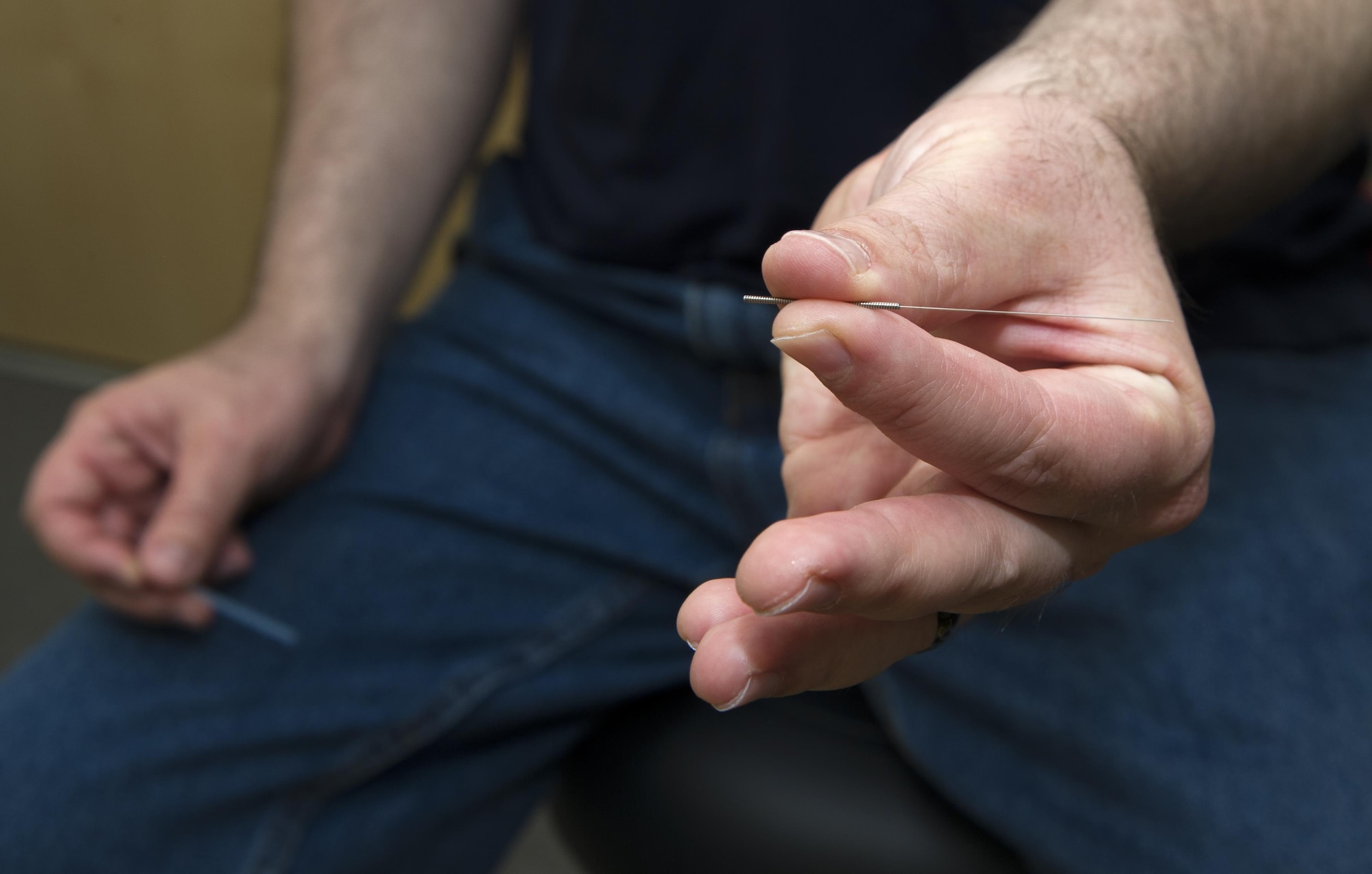 Tim Iliff, a licensed acupuncturist with the 673d Surgical Operations Squadron, holds an acupuncture needle during a patient's visit to the Pain Clinic, Joint Base Elmendorf-Richardson, Alaska, April 27, 2017. A thin acupuncture needle is inserted into the body's acupuncture points commonly used for pain relief and a variety of other conditions. 