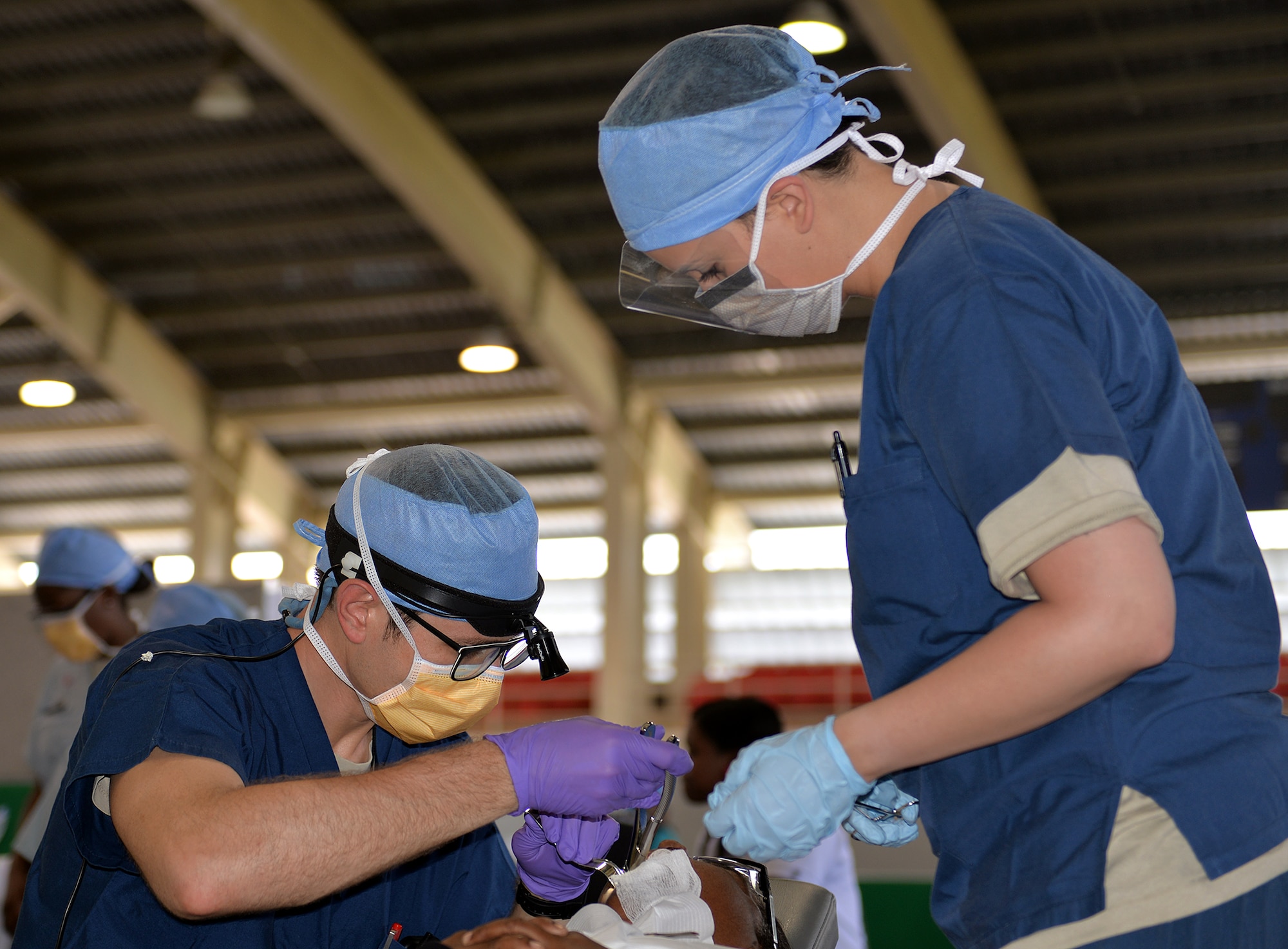 U.S. Air Force Capt. Caleb English, an oral and maxillofacial surgeon with the 633rd Medical Group out of Joint Base McGuire-Dix-Lakehurst, Va., performs oral surgery with the assistance of Senior Airman Caitlin Moore, a dental assistant with the 81st Dental Squadron out of Keesler Air Force Base, Miss., March 14, 2017, during a dental readiness training exercise in Azua, Dominican Republic, as part of NEW HORIZONS 2017. The training provided by NEW HORIZONS missions promotes bilateral cooperation between U.S. and partner nation military engineers, medical personnel and support staff, and ensures U.S. forces remain prepared for real-world deployments in support of contingency, humanitarian assistance, and disaster relief operations. (U.S. Air Force photo by Master Sgt. Karen J. Tomasik)