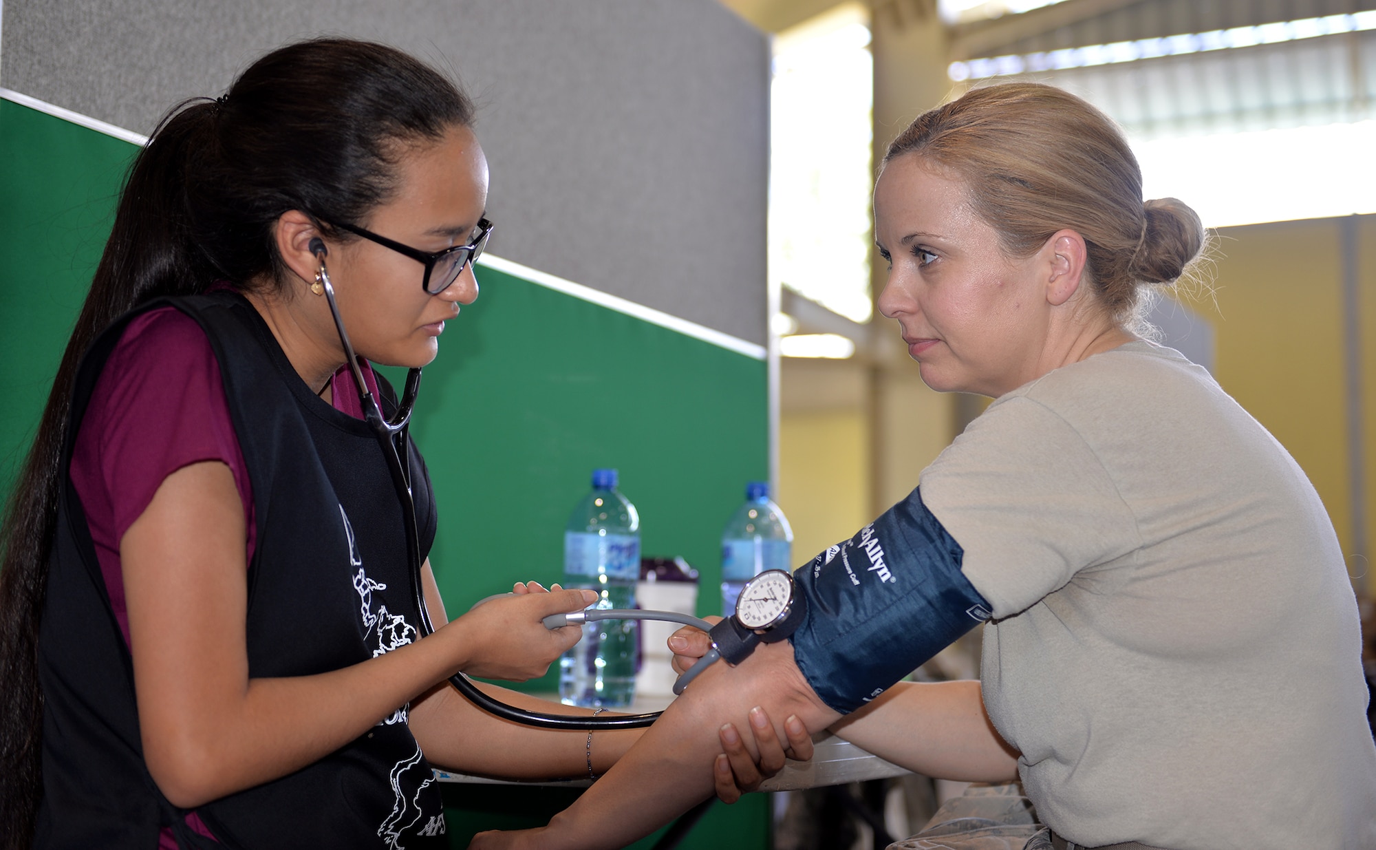 U.S. Air Force Capt. Natasha Lewis, a nurse with the 21st Medical Operations Squadron out of Peterson Air Force Base, Colo., has a local medical student volunteer take her blood pressure during a break between seeing patients in Azua, Dominican Republic, March 14, 2017, during a medical readiness training exercise as part of NEW HORIZONS 2017. Non-governmental organization (NGO)/private voluntary organization and private sector participation in NEW HORIZONS, coordinated with 12 Air Force, U.S. Southern Command, the Department of State, and the U.S. agency for International Development, nurtures partnerships between the military services, governmental, NGOs, and host-nation teams to ensure partnerships are in place in the event of a regional contingency requiring cooperative solutions. (U.S. Air Force photo by Master Sgt. Karen J. Tomasik)