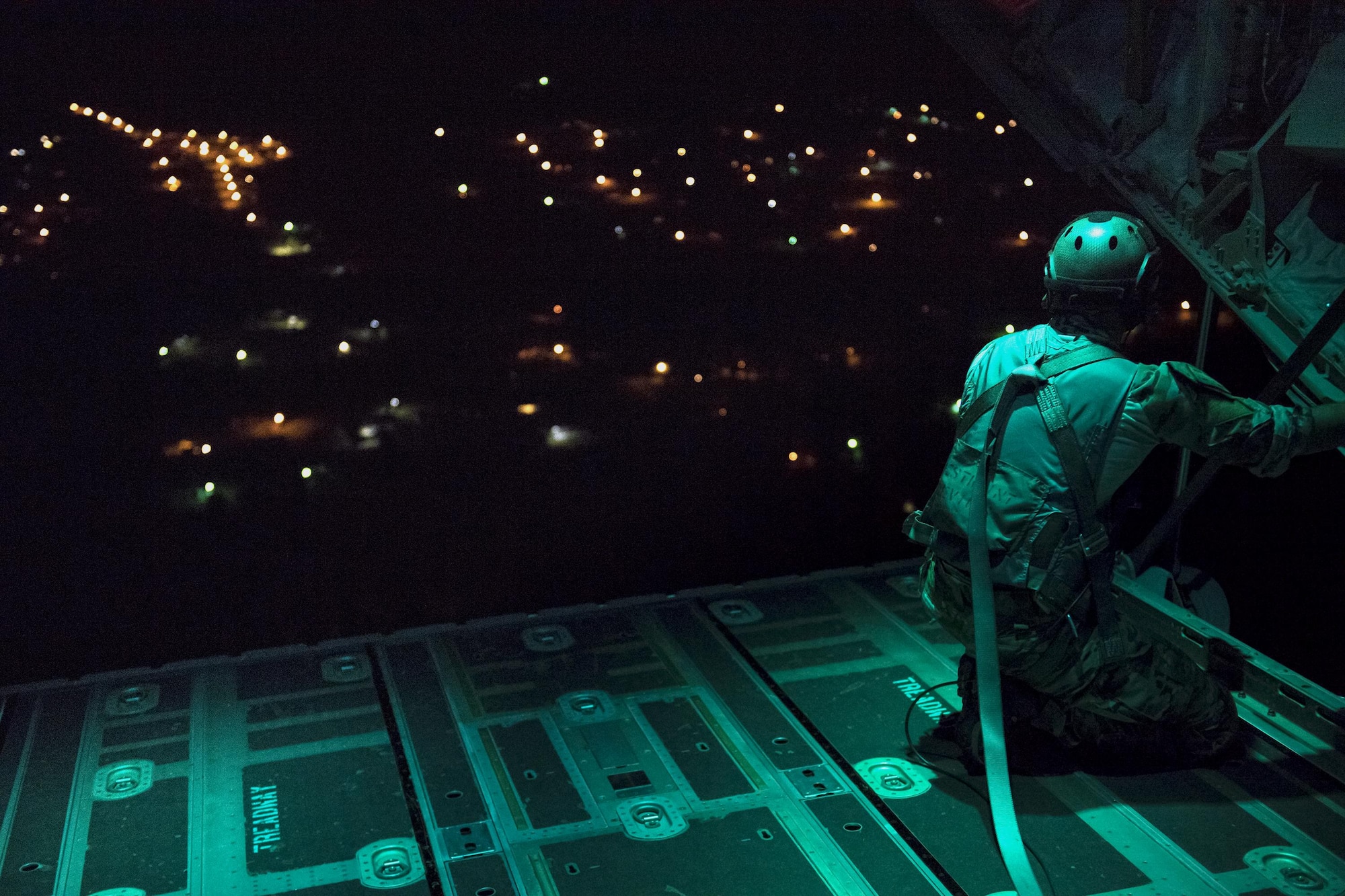 A pararescueman from the 38th Rescue Squadron scans the drop zone from the back of an HC-130J Combat King II prior to static-line jumps, April 24, 2017, at Moody Air Force Base, Ga. All PJs are qualified to conduct both static-line and High altitude, low opening jumps. During a static-line jump, the jumper is attached to the aircraft via the ‘static-line’, which automatically deploys the jumpers’ parachute after they’ve exited the aircraft. (U.S. Air Force photo by Staff Sgt. Ryan Callaghan)