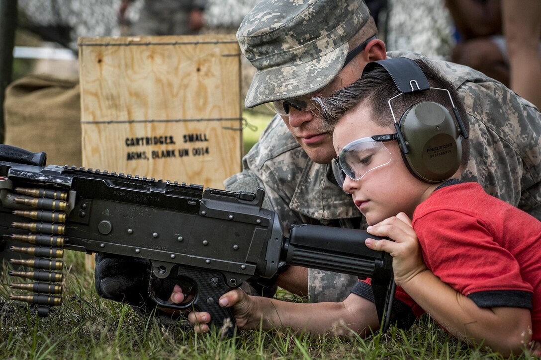 A soldier talks with a child about a machine gun during the 6th Ranger Training Battalion’s open house event at Eglin Air Force Base, Fla., April 29, 2017. The event provided an opportunity for the public to learn how Rangers train and operate. Air Force photo by Samuel King Jr.