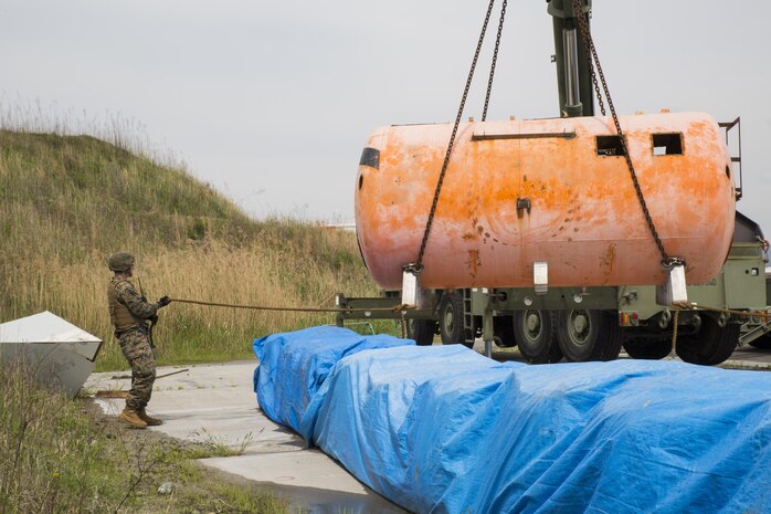 U.S. Marine Corps Cpl. Nicolas Fletcher, a heavy equipment operator with Marine Wing Support Squadron (MWSS) 171, helps guide a tank onto a trailer during a simulated aircraft crash scenario for exercise Tanuki Wrath at Marine Corps Air Station Iwakuni, Japan, April 27, 2017.  Marines with MWSS- 171 and Aircraft Rescue and Firefighting simulated aircraft salvage and recovery operations. The exercise keeps Marines prepared to react appropriately in the case an aircraft crash. (U.S. Marine Corps photo by Pfc. Mason Roy)