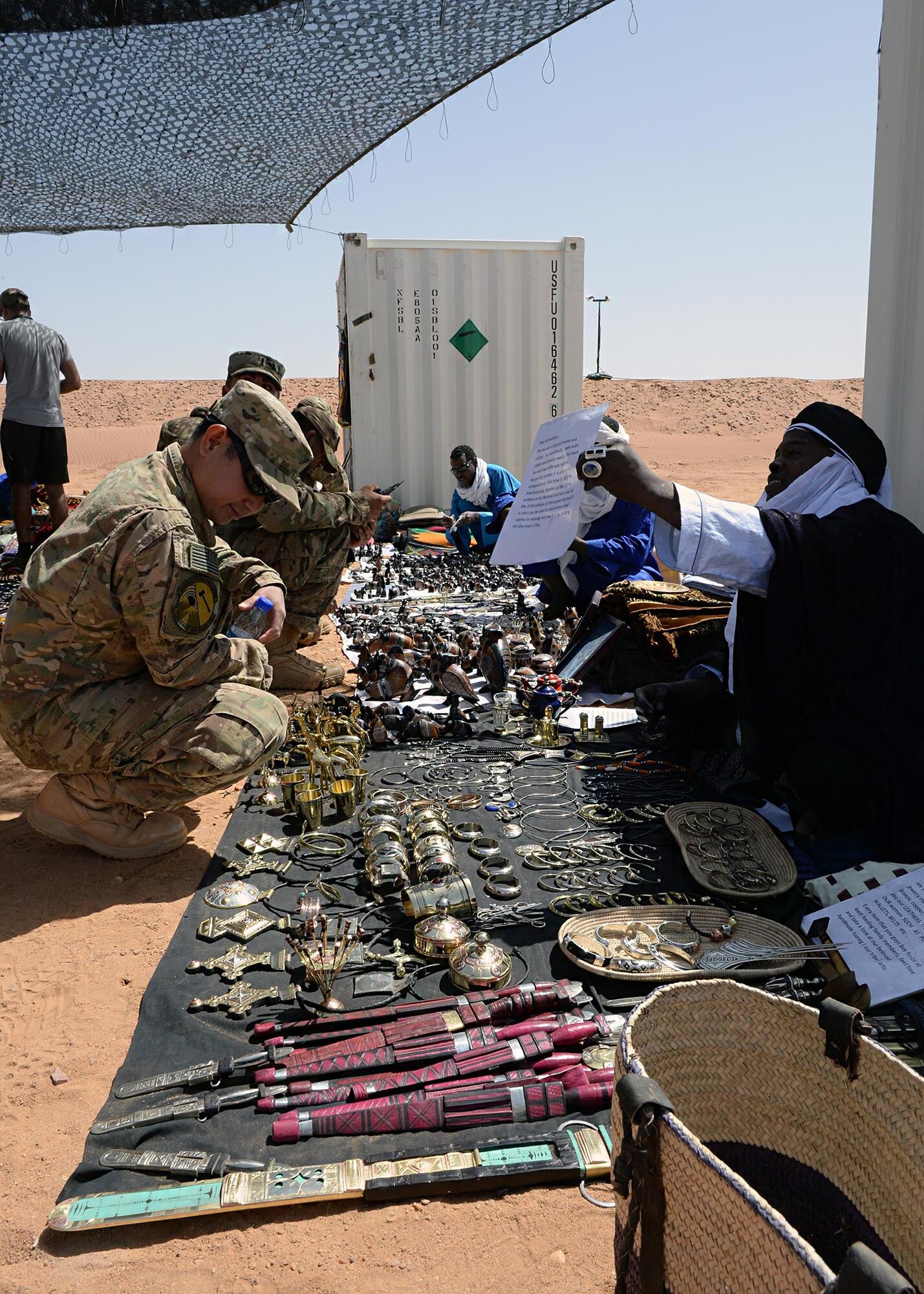 Airmen shop through merchandise during a bazaar at Nigerien Air Base 201, Niger, April 16, 2017. More than 15 merchants participated in the bazaar, bringing local goods for Airmen to purchase as gifts and souvenirs. (U.S. Air Force photo by Senior Airman Jimmie D. Pike)