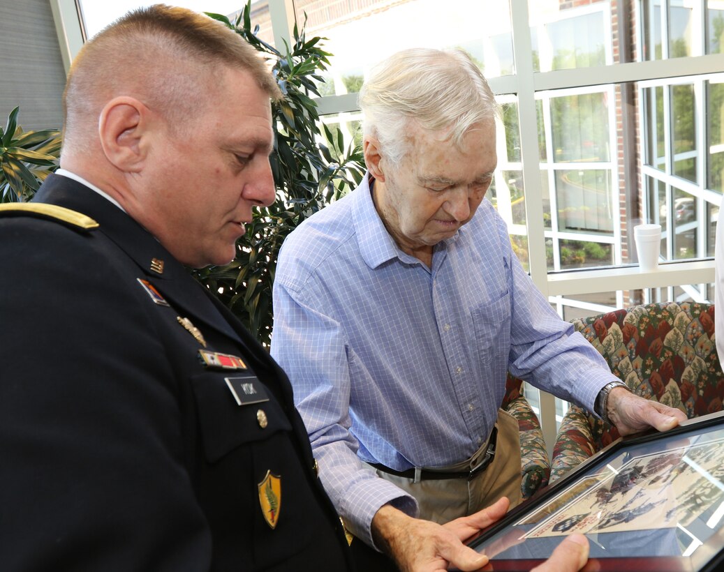 Maj. Gen. Troy D. Kok, commanding general of the U.S. Army Reserve’s 99th Regional Support Command, presents framed artwork from World War II to Claude Hodges, a 99th Infantry Division veteran who served during the Battle of the Bulge and is currently a resident at the Virginia Veterans Care Center in Roanoke, Virginia. Kok visited Hodges and other veterans at the center April 28.