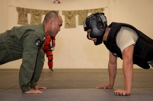 Staff Sgt. John Weakley, left, 86th Security Forces Squadron Raven team leader, leads Airman 1st Class Damien Monreal, 86th SFS alarm monitor, in a set of pushups on Ramstein Air Base, Germany, April 27, 2017. Monreal trained in the techniques that he will use in the Phoenix Raven qualification course, such as proper baton strikes and stance. Phoenix Ravens are specially trained security forces personnel dedicated to providing security for Air Mobility Command aircraft transiting high terrorist and criminal threat areas. (U.S. Air Force photo by Senior Airman Elizabeth Baker/Released)