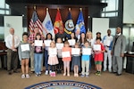 Parents and children pose with Sultan Muhammad, deputy director of Installation Support for the HQC, on National Take Our Daughters and Sons to Work Day, April 27.