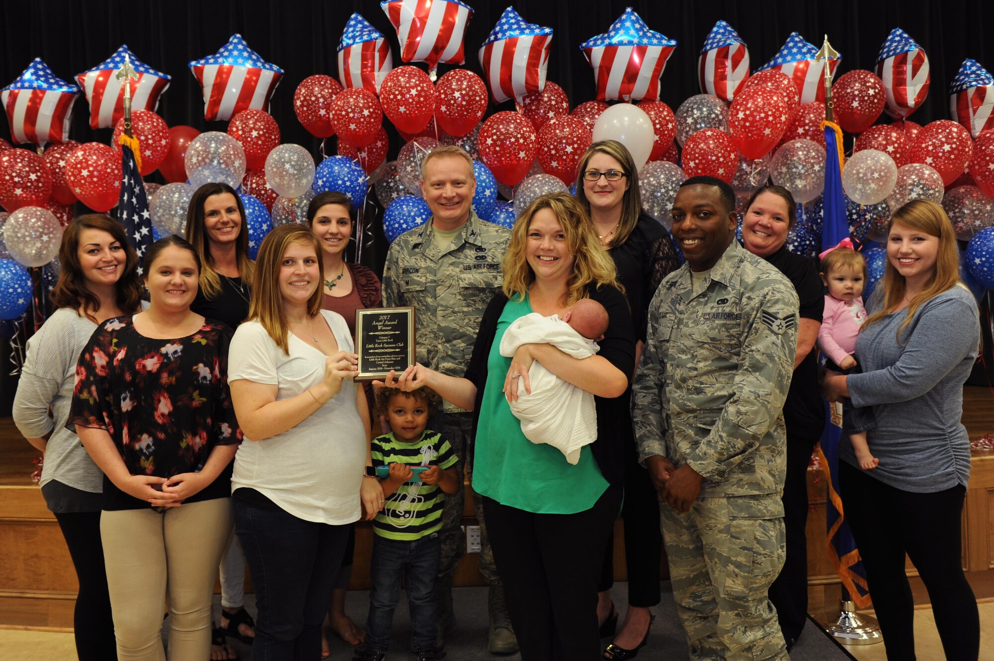 Members of the Little Rock Spouses' Club receive the award for a group of three or more individuals during the Airman & Family Readiness Center Volunteer Program ceremony, April 27, 2017 at Little Rock Air Force Base, Ark. The members contributed more than 1,700 hours to fundraising and assisting with or creating installation events. (U.S. Air Force photo by Airman 1st Class Grace Nichols)