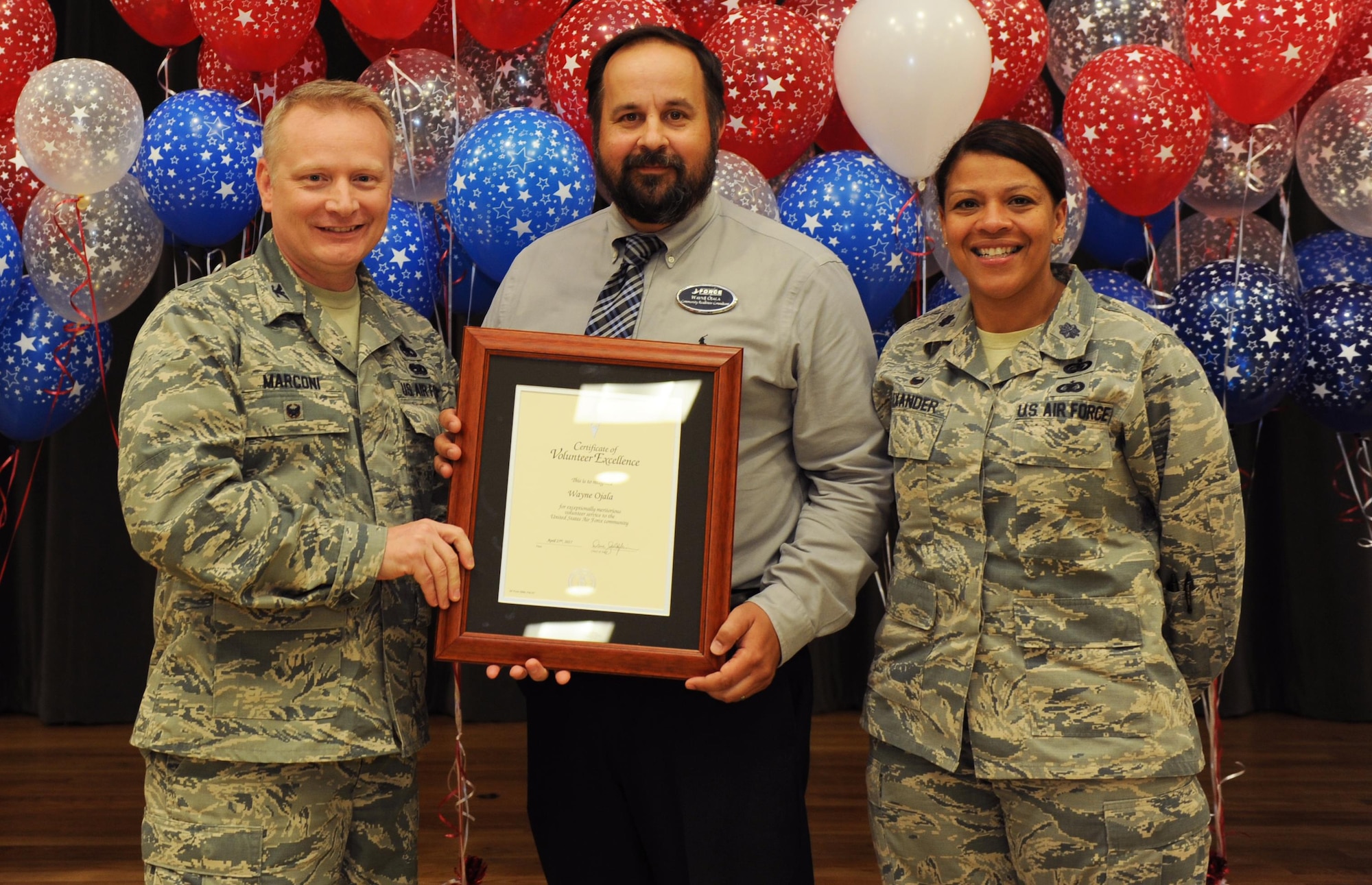 Wayne Ojala, Airman & Family Readiness Center community readiness consultant, receives the Volunteer Excellence Award during the A&FRC Volunteer Program ceremony, April 27, 2017 at Little Rock Air Force Base, Ark. Ojala was recognized for fostering children from the local community; he spent more than 40 hours training to be a foster parent. (U.S. Air Force photo by Airman 1st Class Grace Nichols)