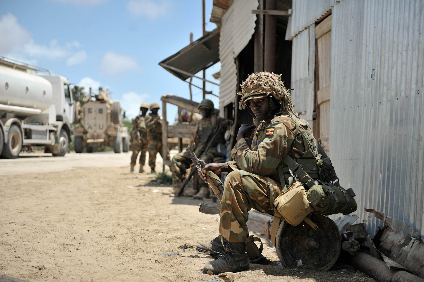 In 2014, a Ugandan soldier serving with AMISOM rests in advance of an AU and Somali National Force operation to liberate the Somali town of Barawe from the extremist group al-Shabaab.  
