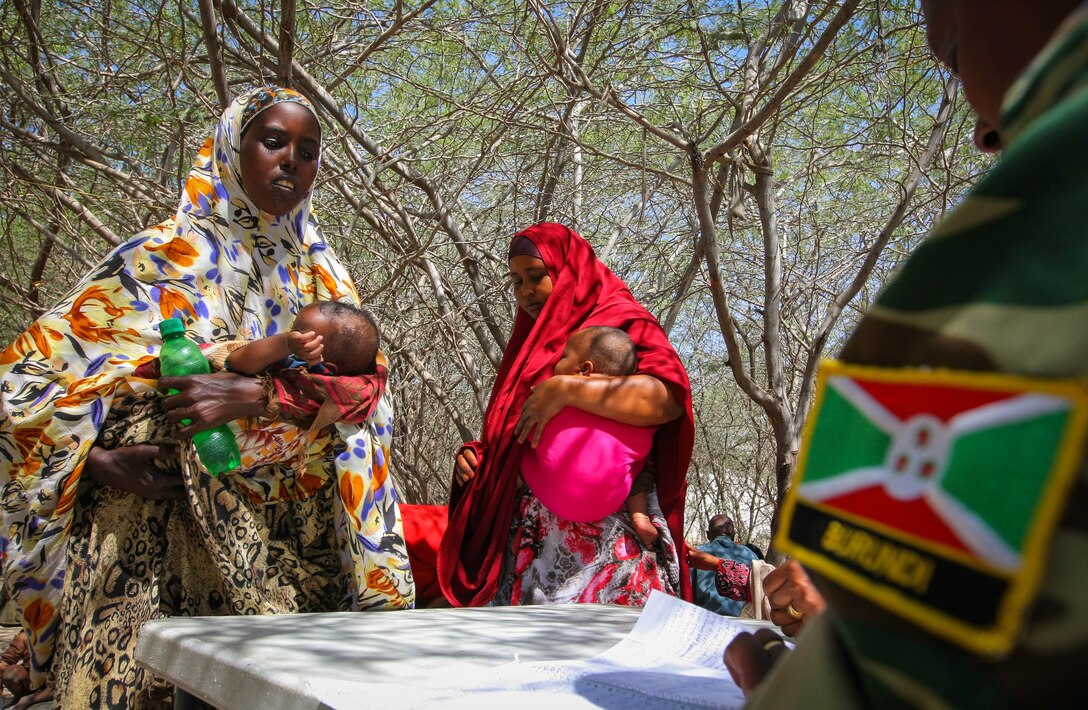 A female Burundian medical officer serving with the African Union Mission in Somalia (AMISOM) in 2013 speaks with Somali women at a free medical clinic in Mogadishu, where
medical care was a lifeline for thousands of civilians who were caught up and injured during fighting with al-Shabaab. (Stuart Price/AMISOM posted by Albany Associates)