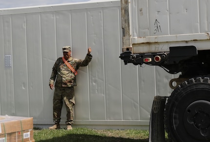 U.S Army Reserve 1st Sgt. Class Chahutemoc Martinez, Truck Master for the 851st Transportation Company, based in Sinton, Texas, guides the delivery of a refrigerated conex during Vibrant Response and Guardian Response near Camp Atterbury, Indiana, Apr. 25, 2017.  Vibrant Response and Guardian Response bring together military, federal and state agencies from throughout the continental U.S. for three weeks of collective training simulating the response to a catastrophic Chemical Biological Radiological Nuclear (CBRN) event in a major U.S. city.  (U.S. Army Reserve Photo by Maj. Brandon R. Mace)