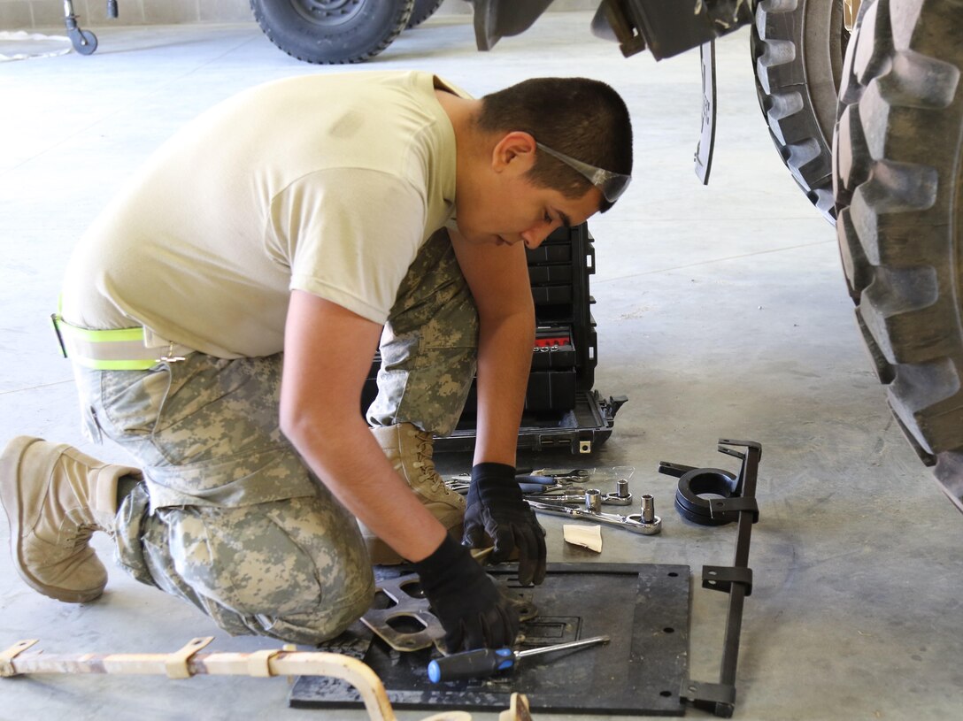 U.S Army Reserve Spc. Jaime Garcia, a wheeled vehicle mechanic with the 851st Transportation Company, based in Sinton, Texas, conducts maintenance on a M1075A1 Palletized Load System during Vibrant Response and Guardian Response near Camp Atterbury, Indiana, Apr. 25, 2017.  Vibrant Response and Guardian Response bring together military, federal and state agencies from throughout the continental U.S. for three weeks of collective training simulating the response to a catastrophic Chemical Biological Radiological Nuclear (CBRN) event in a major U.S. city.  (U.S. Army Reserve Photo by Maj. Brandon R. Mace)