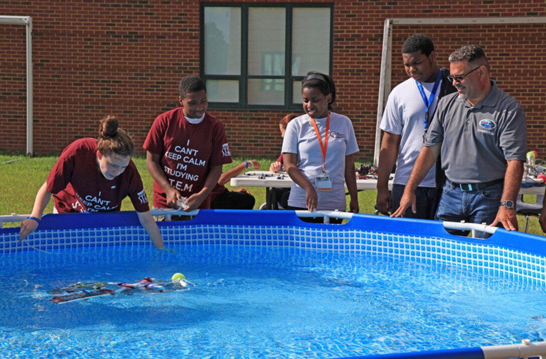 MARMC Vertical Launch System & Combat Systems Alignment Branch Head John Rivera assists Heritage High students in demonstrating their sea perch submersibles at the most recent Heritage High Governor’s STEMulating Minds Expo Day. (Photo by Shelby West, Public Affairs Specialist)