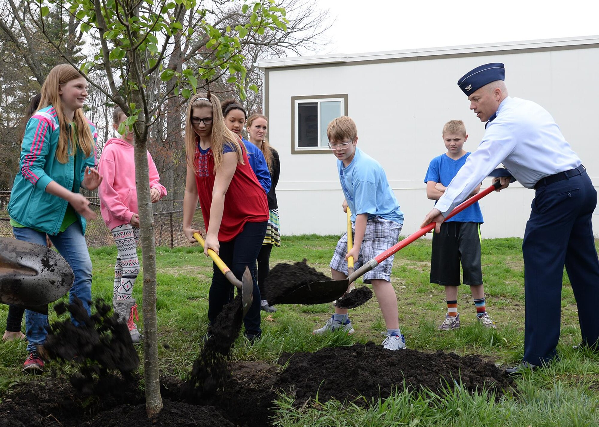 Col. Roman L. Hund, installation commander, and Hanscom Middle School students plant a pear tree along Eglin Street as part of Arbor Day activities at Hanscom Air Force Base, Mass., April 28. Arbor Day is celebrated the last Friday in April and is used to recognize how trees enrich people's lives. (U.S. Air Force photo by Linda LaBonte Britt)
