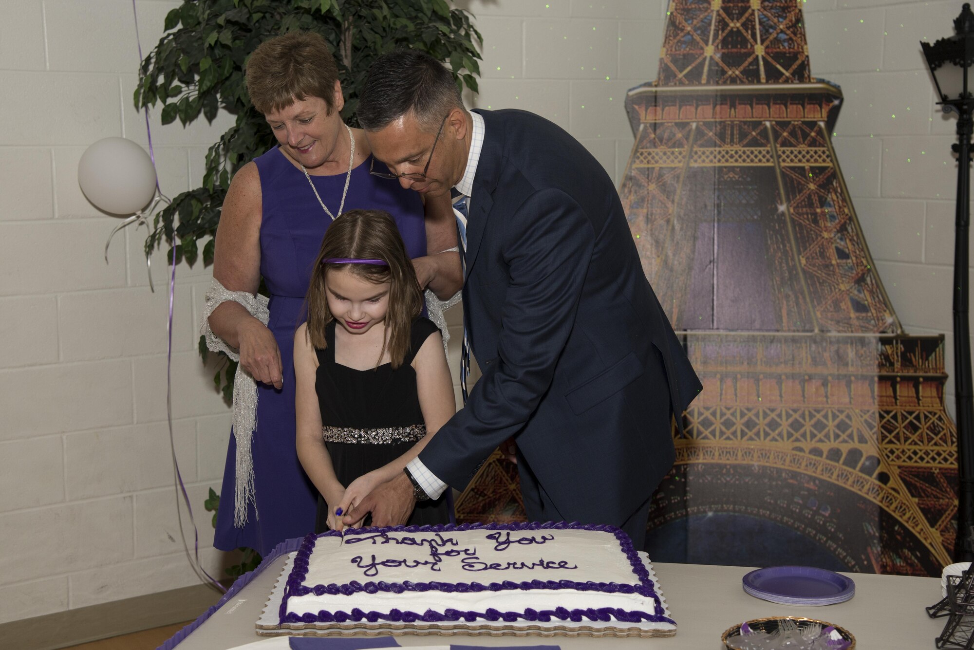 Karen Bradley, 436th Force Support Squadron Airman and Family Services flight chief, Col. Randy Boswell, 436th Mission Support Group commander, and Tory Ruhm, daughter of Staff Sgt. Michael Ruhm, 436th Maintenance Squadron crew chief, cut the cake during Team Dover’s inaugural Purple Ball April 29, 2017, at the Youth Center on Dover Air Force Base, Del. The ball was organized to support military families during the Month of the Military Child, which is a commemorate month celebrated each April. (U.S. Air Force photo by Senior Airman Aaron J. Jenne)