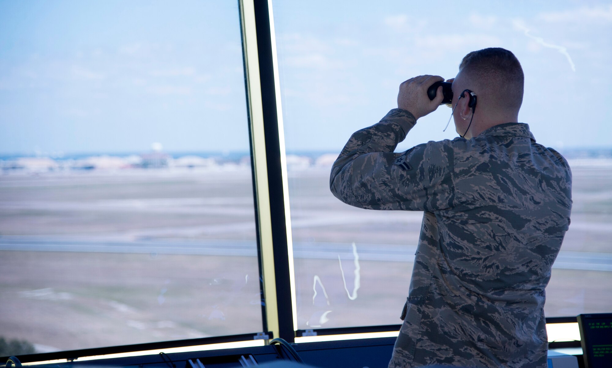 U.S. Air Force Airman 1st Class Tyler Abell, an air traffic control apprentice assigned to the 6th Operations Support Squadron, uses binoculars to spot an incoming aircraft April 27, 2017, at MacDill Air Force Base, Fla. The 6th Air Mobility Wing’s Air Traffic Control Tower won Air Mobility Command’s air traffic control tower of the year for 2016. (U.S. Air Force photo by Airman 1st Class Rito Smith) 