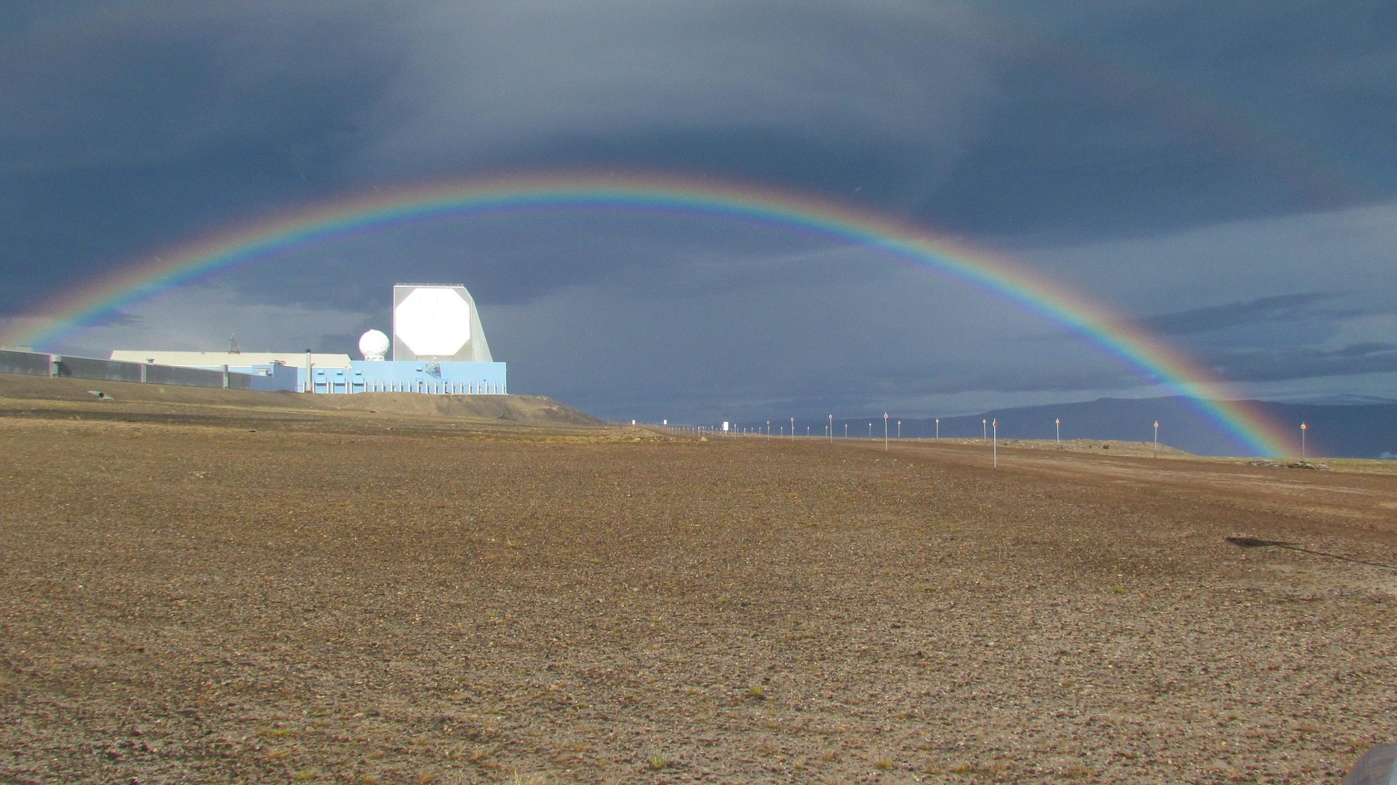 A rainbow arches above the phased-array radar system at Ballistic Missile Early Warning System – I, at Thule Air Base, Greenland. The site is operated by the 12th Space Warning Squadron, a geographically separated unit of the 21st Space Wing at Peterson Air Force Base, Colo. The Air Force Life Cycle Management Center, Hanscom Air Force Base, Mass., awarded a $40 million contract Dec., 2016 to Raytheon Integrated Defense Systems to upgrade hardware and software at the site. (Courtesy Photo)