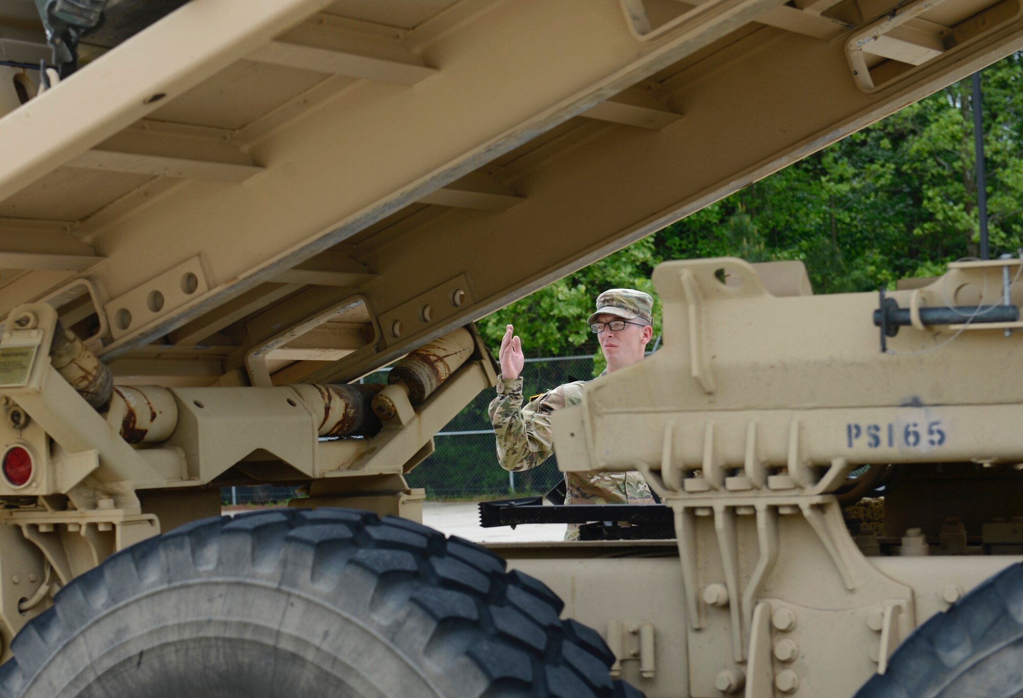 U.S. Army Pvt. Daniel Mitchell, 688th Rapid Port Opening Element motor transport operator, signals a vehicle operator during an exercise at Joint Base Langley-Eustis, Va., April 26, 2017. The 688th RPOE Soldiers perform exercises regularly to hone their skills and capabilities within the field. (U.S. Air Force photo/Airman 1st Class Kaylee Dubois)