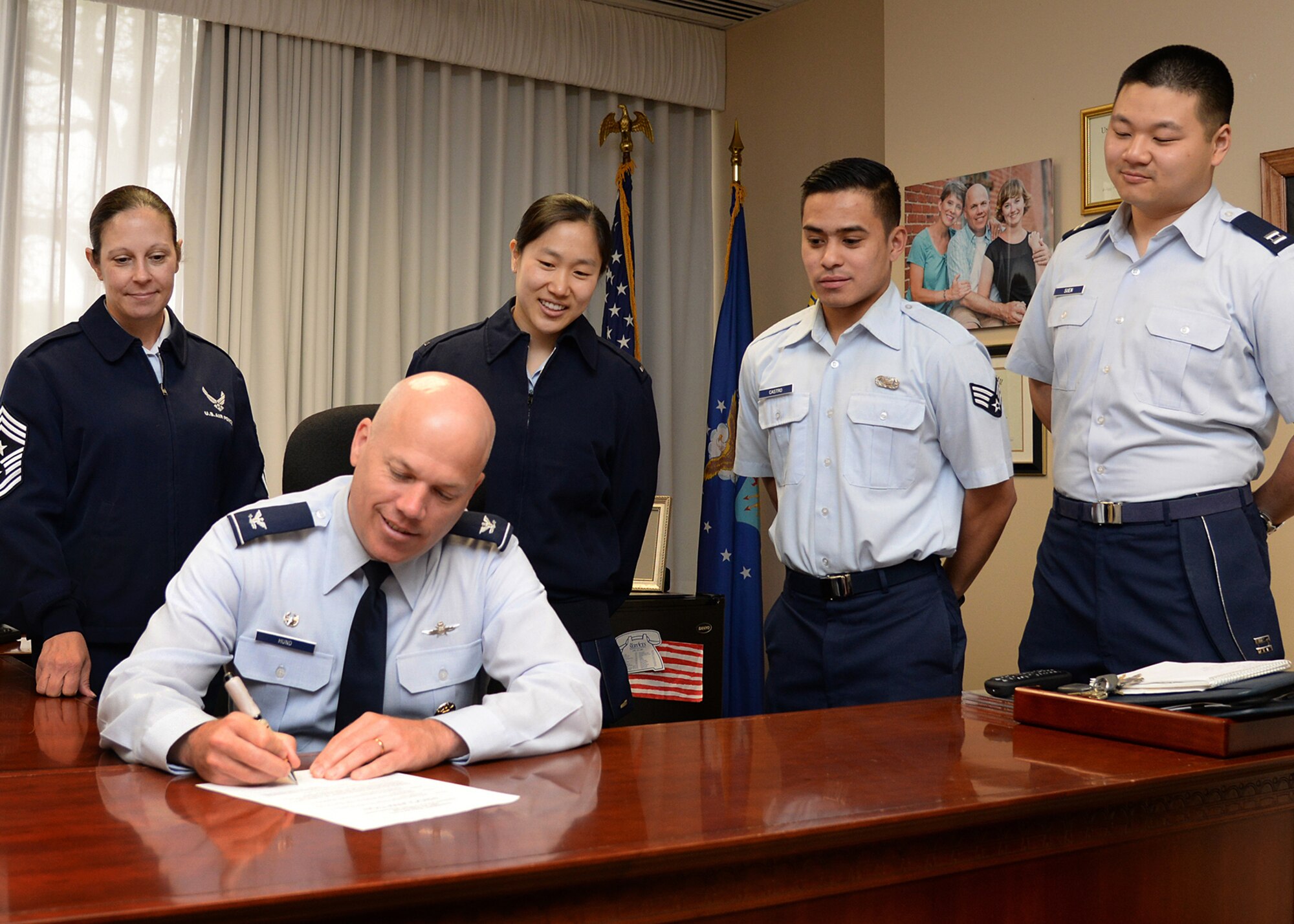 Col. Roman L. Hund, installation commander, signs a proclamation establishing May as Asian American Pacific Islander Heritage Month at Hanscom Air Force Base, Mass., May 1, while Command Chief Master Sgt. Patricia L. Hickey, left, 1st Lt. Yeoju Kim, Senior Airman Martin Jerome Castro and Capt. Kenneth Suen look on. The proclamation calls upon all military, civilian and family members at Hanscom to mark the monthlong observance by participating in base wide activities, sponsored by the Asian Pacific American Heritage committee. (U.S. Air Force photo Linda LaBonte Britt)